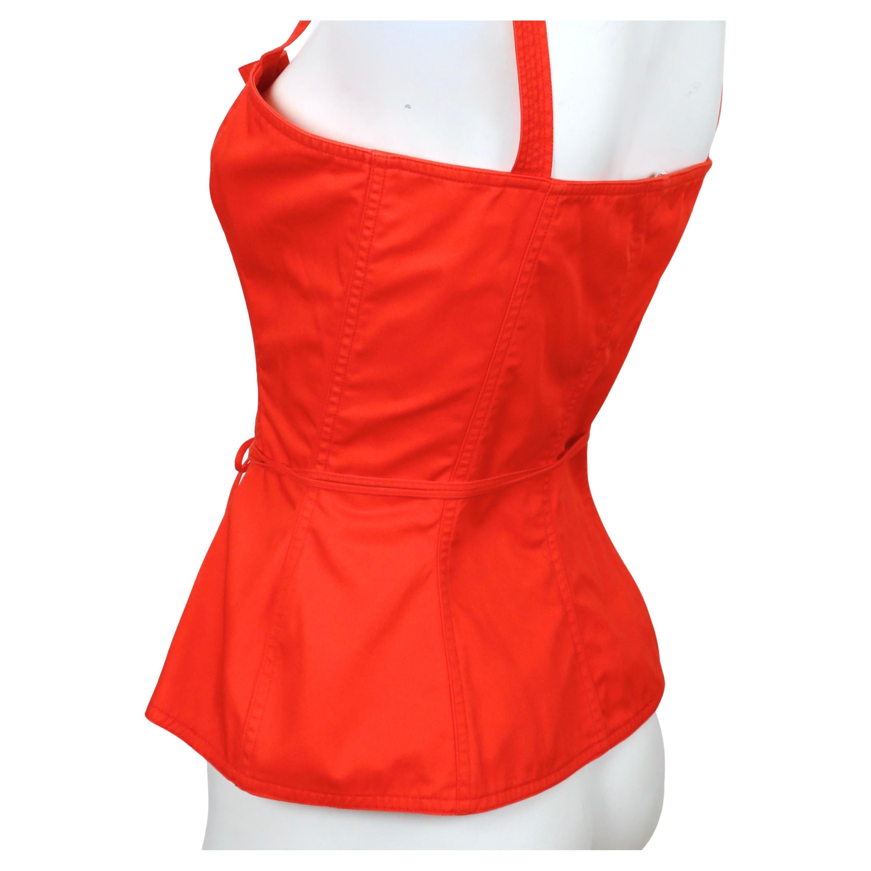 Red cotton bustier top with metal grommets designed by Yves Saint Laurent dating to 1977 exactly as seen on the runway and in numerous editorials including one of Farah Fawcett. Best fits a size 4 to 6 (maximum bust of 33.5