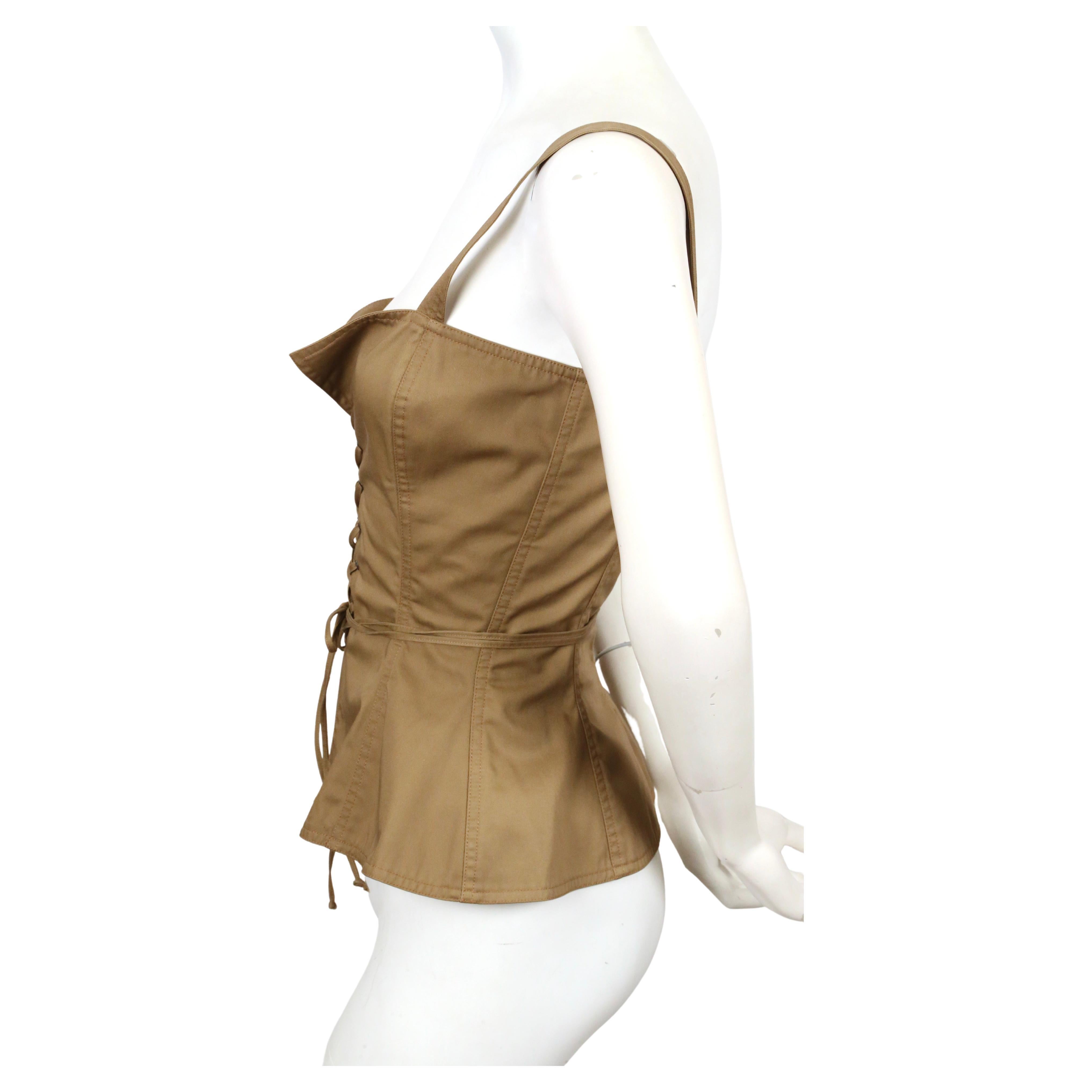 Tan, cotton bustier top with metal grommets designed by Yves Saint Laurent dating to 1977 exactly as seen on the runway and in numerous editorials including one of Farrah Fawcett. No size is indicated however this best fits a size 2 to 4 (maximum