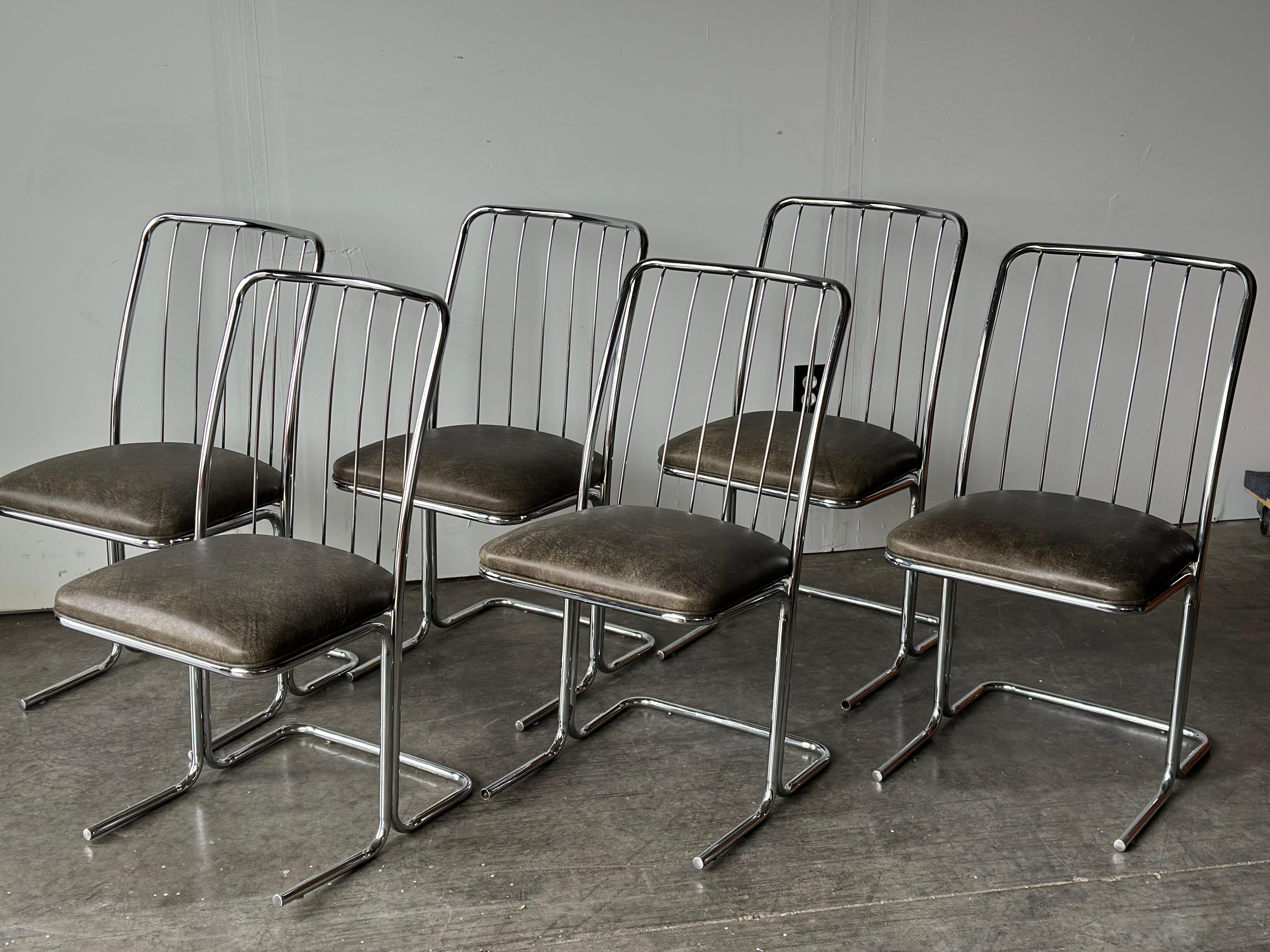 Set of 6 chrome with leather cantilevered Daystrom chairs featuring a wire back, curved top from, and straight parallel feet to stabilize. Chairs have been carefully cleaned and restored. New deep/dark green leather seats with piping.

Originally