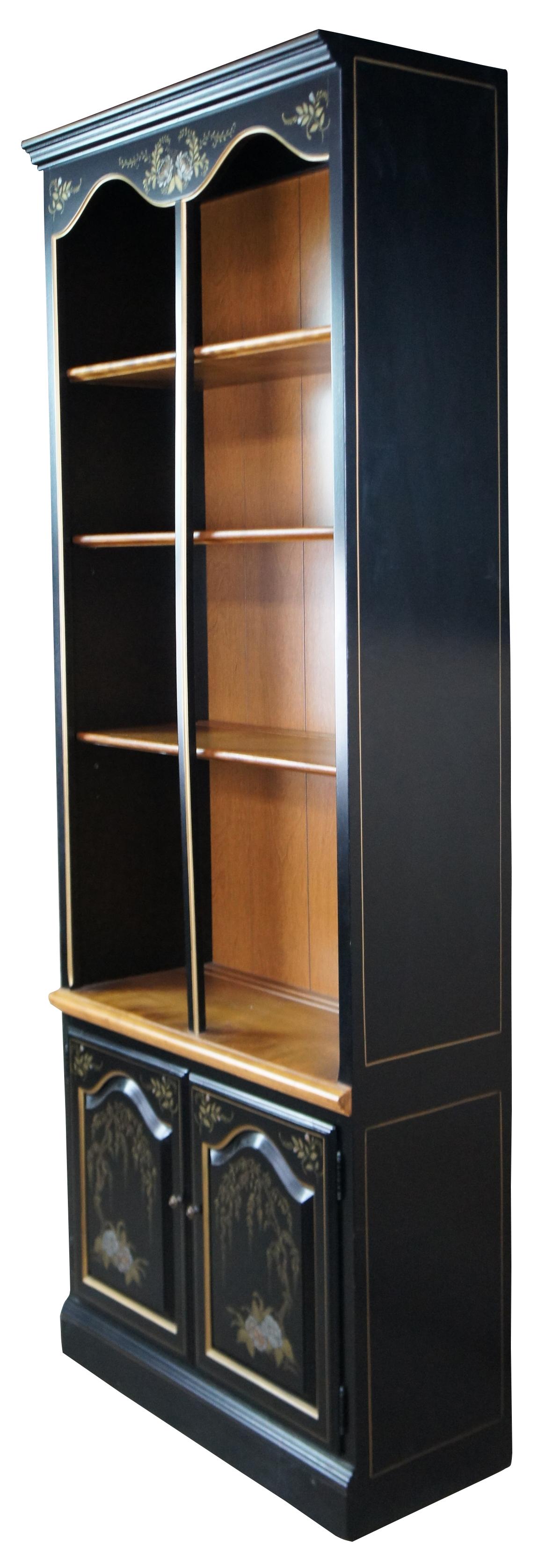 Vintage 1978 Ethan Allen library bookstack No. 14-9026 finish 610. Part of the Hand Decorated Collection. Made of black lacquer and solid maple featuring upper shelves with plate grooves and lower cabinet with hand painted floral details. Shelves