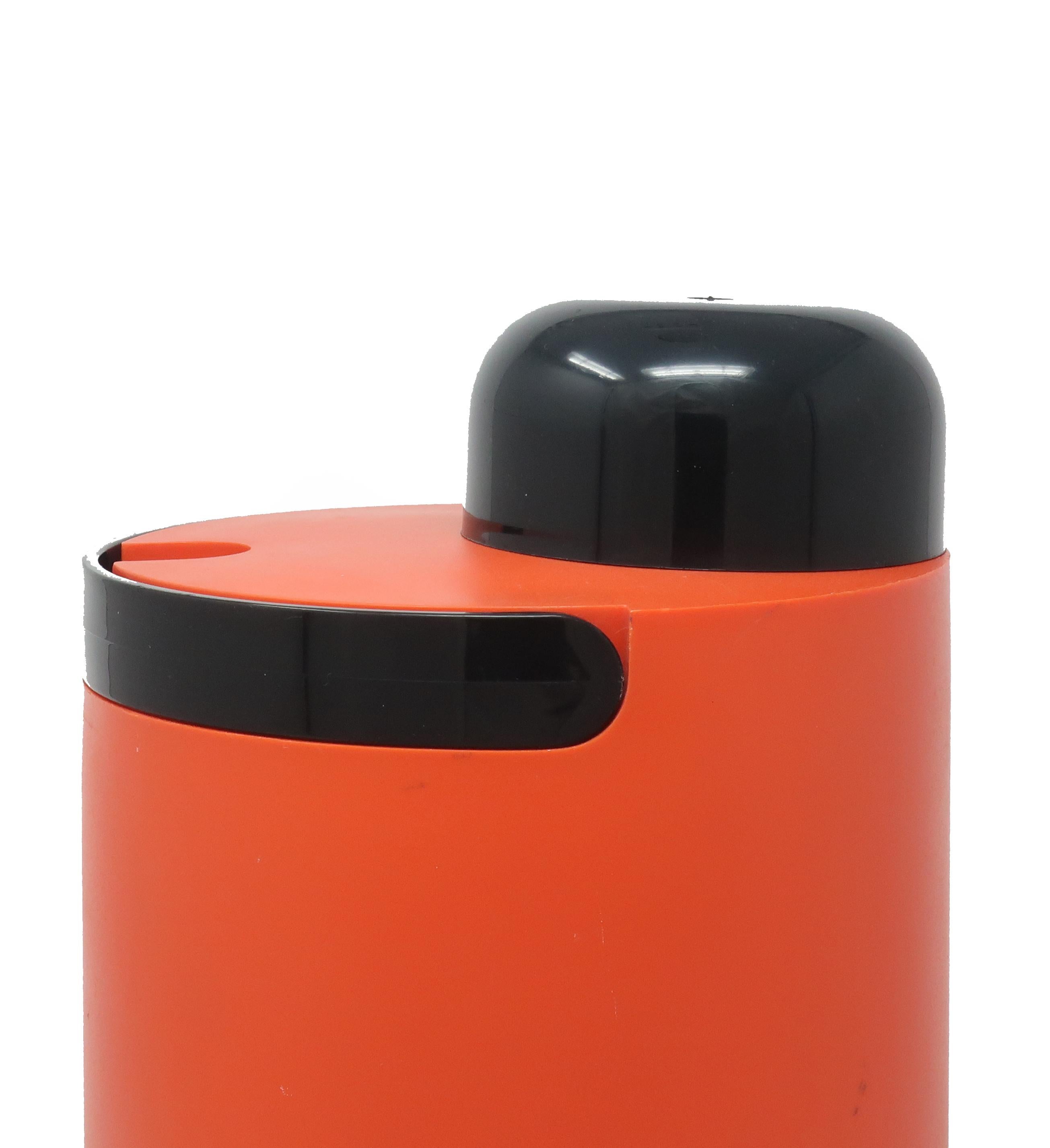An unusual piece from Heller’s midcentury output of amazing plastic products! This thermal jug/cooler has an orange plastic body, black removable cup and pour spout, black folding handle, and clear plastic liner to keep liquids cold or hot. The pour