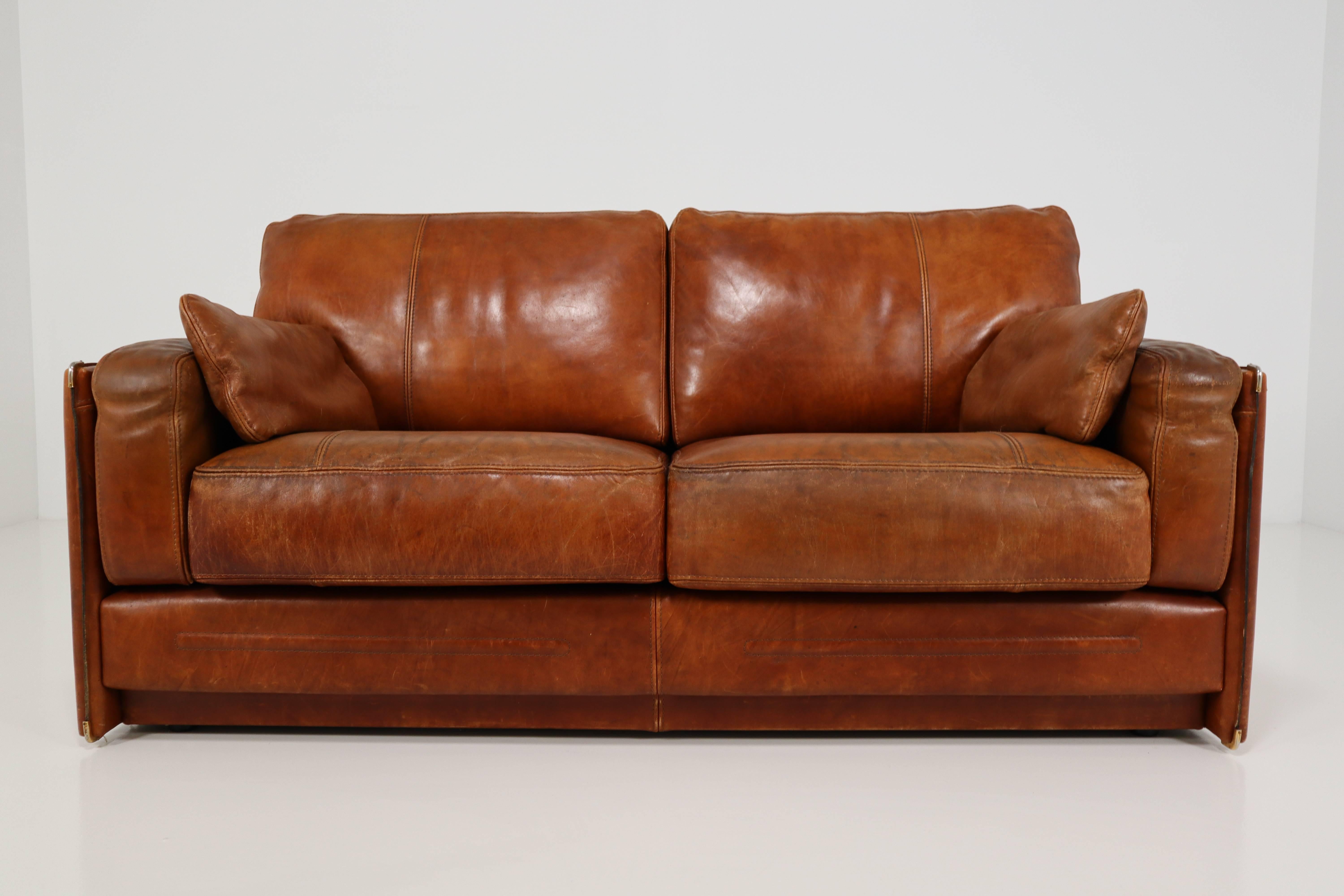 An Italian Baxter bull leather sofa from high quality. The sofa contains an solid wood frame and an distressed thick buffalo hide. We also loved the cognac color of the leather which will work in many surroundings. The condition has tears an