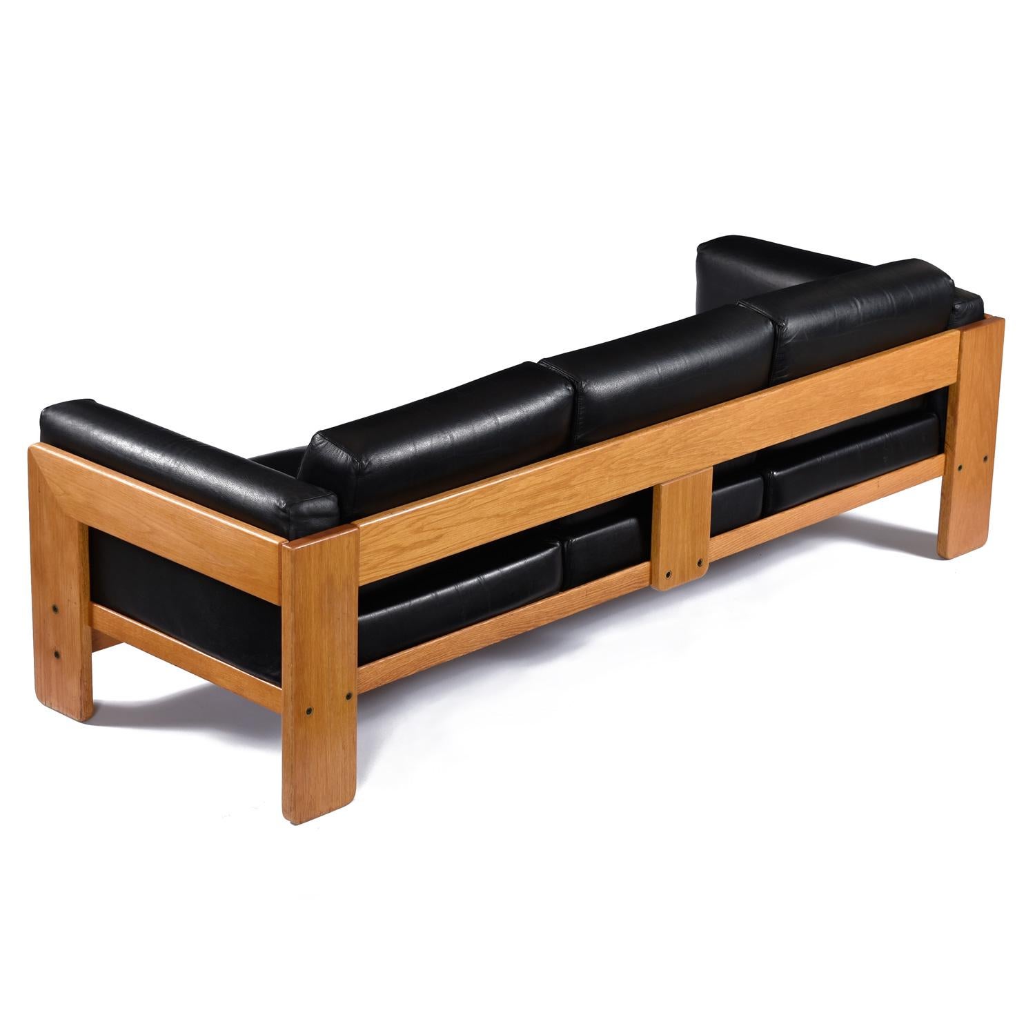 Vintage 1978 Tobia Scarpa for Knoll Bastiano sofa. Black leather against this honeyed oak is the most visually pleasing combination option illustrated by The Bastiano sofa. The leather is thick and durable, yet soft and pliable. Design aficionados
