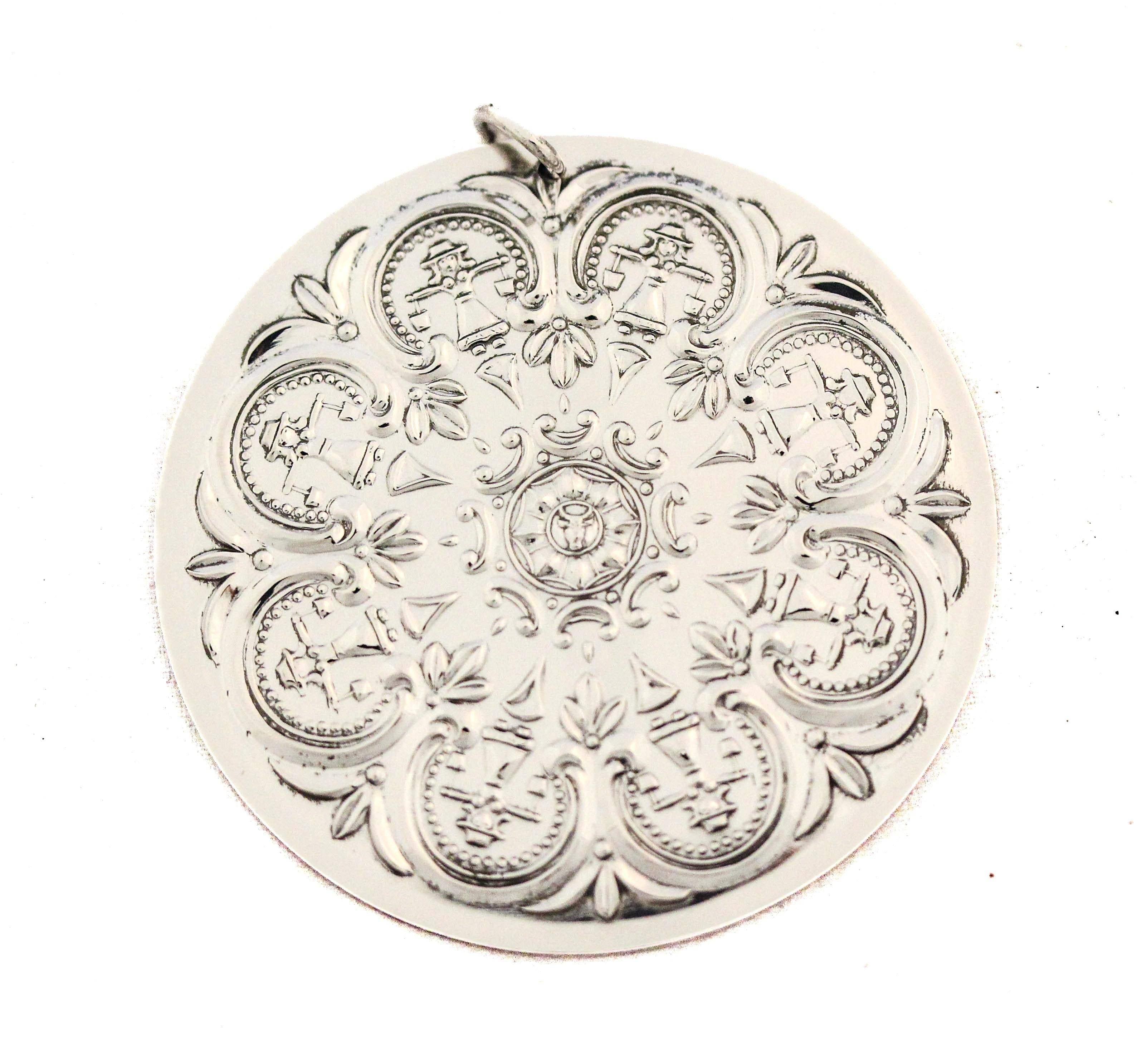 This elegant 1978 sterling silver Christmas medallion by Towle Silversmiths captures the refined craftsmanship and artistic flair that made Towle one of America’s most celebrated silver houses. Created as part of Towle’s annual Christmas ornament