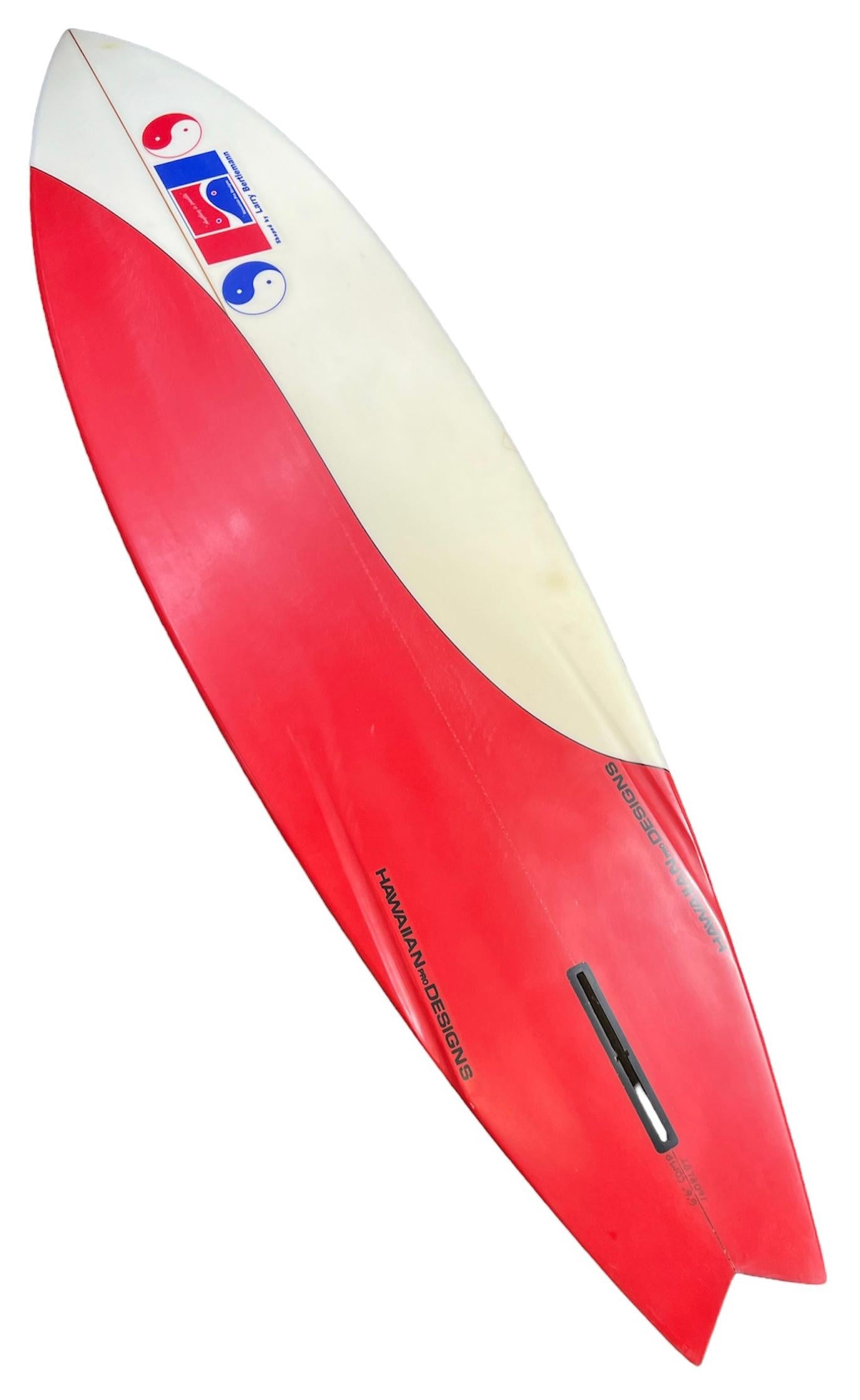 1978 Vintage Larry Bertlemann surfboard. Features Bertlemann’s signature color swirl design in red/white foam with black pinstriping. Signed by Larry Bertlemann. Bertlemann is a renowned surfing star and pioneer of surfing maneuvers hailing from