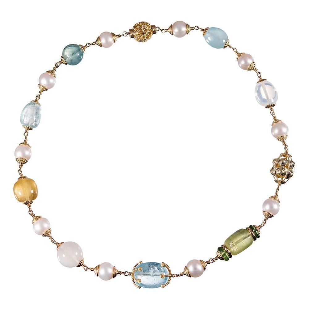 A 21 inch long and visually symbiotic collection of gemstones and pearls, compliments of American jewelry icon Seaman Schepps. The arrangement consists of blue topaz, aquamarine, yellow beryl, moonstone & pearls capped by golden findings and
