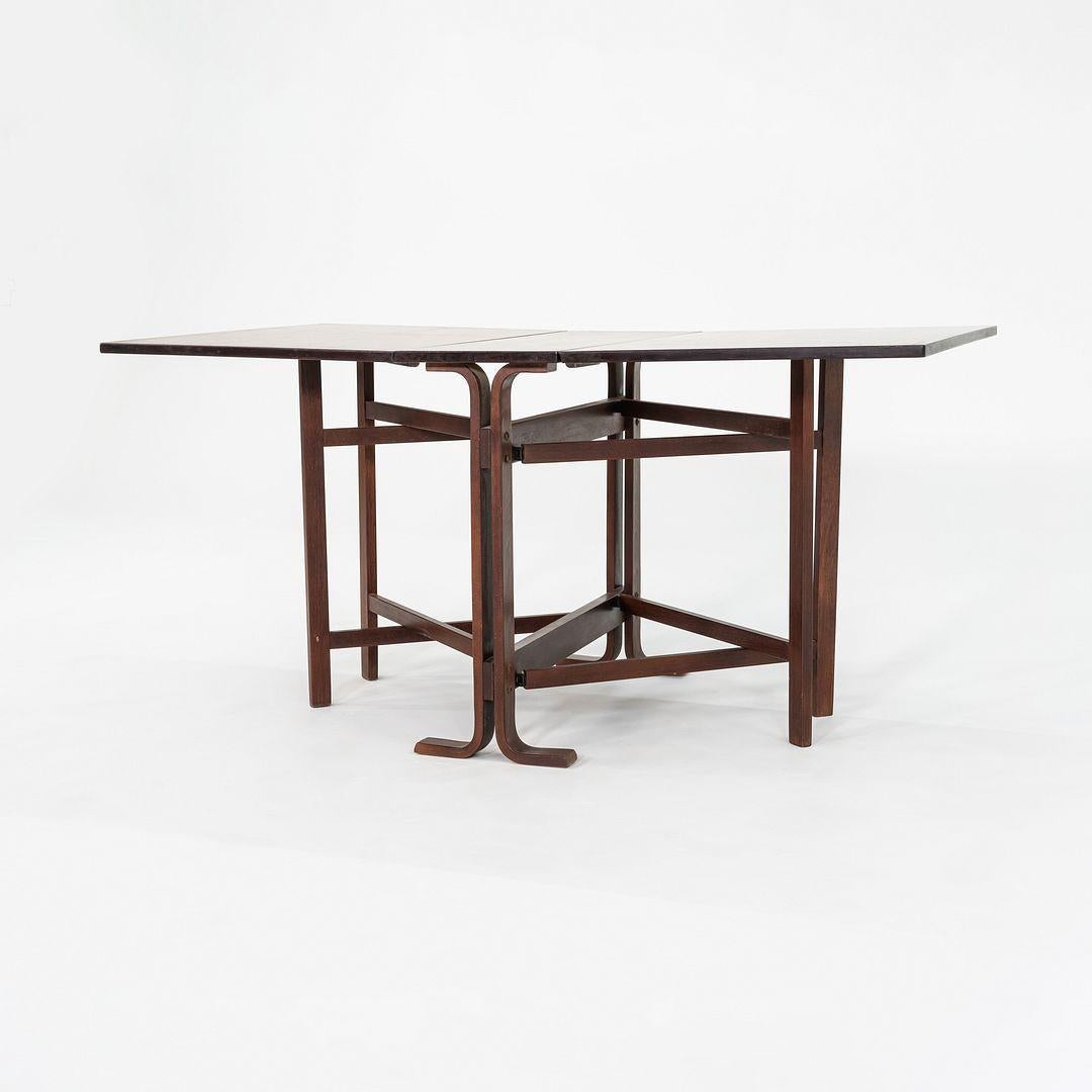 This is a Drop-Leaf Dining Table, Model 56, designed by Bendt Winge for Kleppe Mobelfabrik in Norway in the 1950s. This piece dates to 1979, and is crafted of solid and veneered rosewood. The legs may be teak. The table is versatile, allowing the