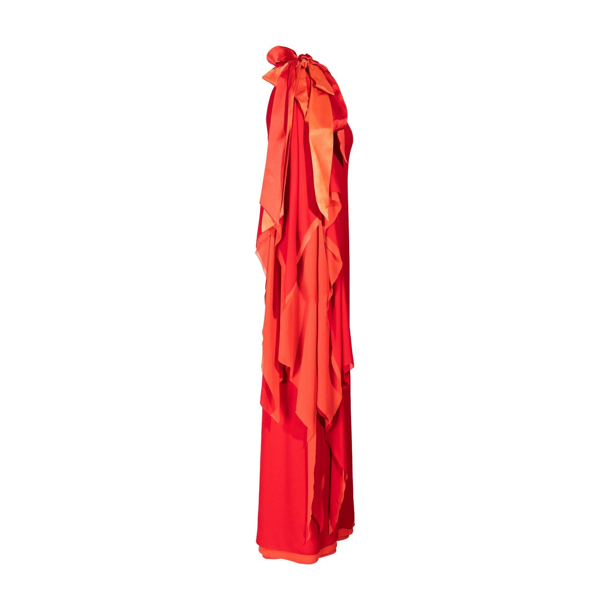 1979 Pierre Cardin Haute Couture red and orange asymmetrical silk chiffon evening gown. One-shoulder gown with long handkerchief hem sleeve on right side and oversized, layered silk bow accent at shoulder. Red-orange exterior silk chiffon with
