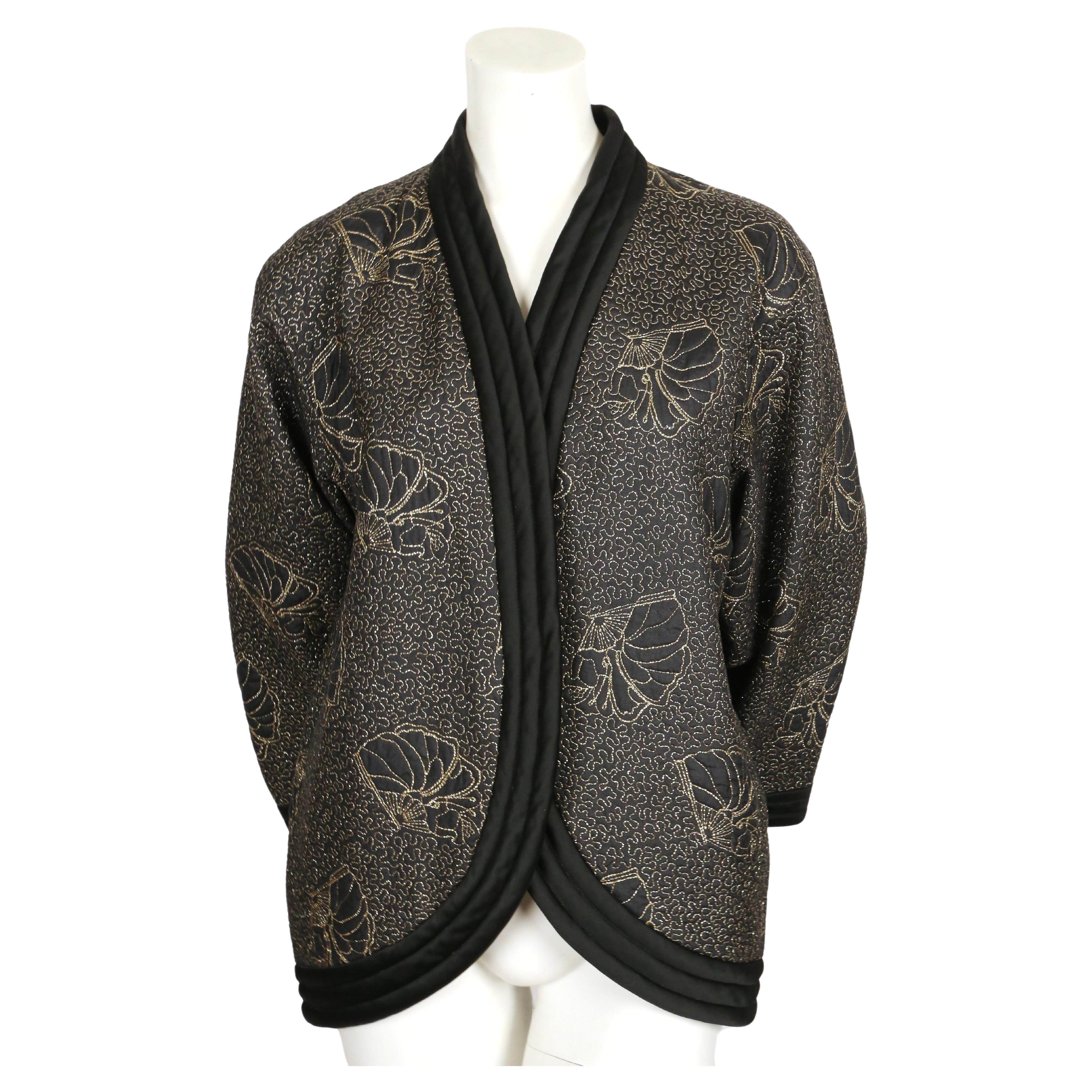 Black, satin kimono jacket with metallic-gold seashell embroidery designed by Yves Saint Laurent dating to 1979. Labeled a French 40 however this fits many sizes due to the oversized cut. Jacket was not clipped on size 2 mannequin. Approximate