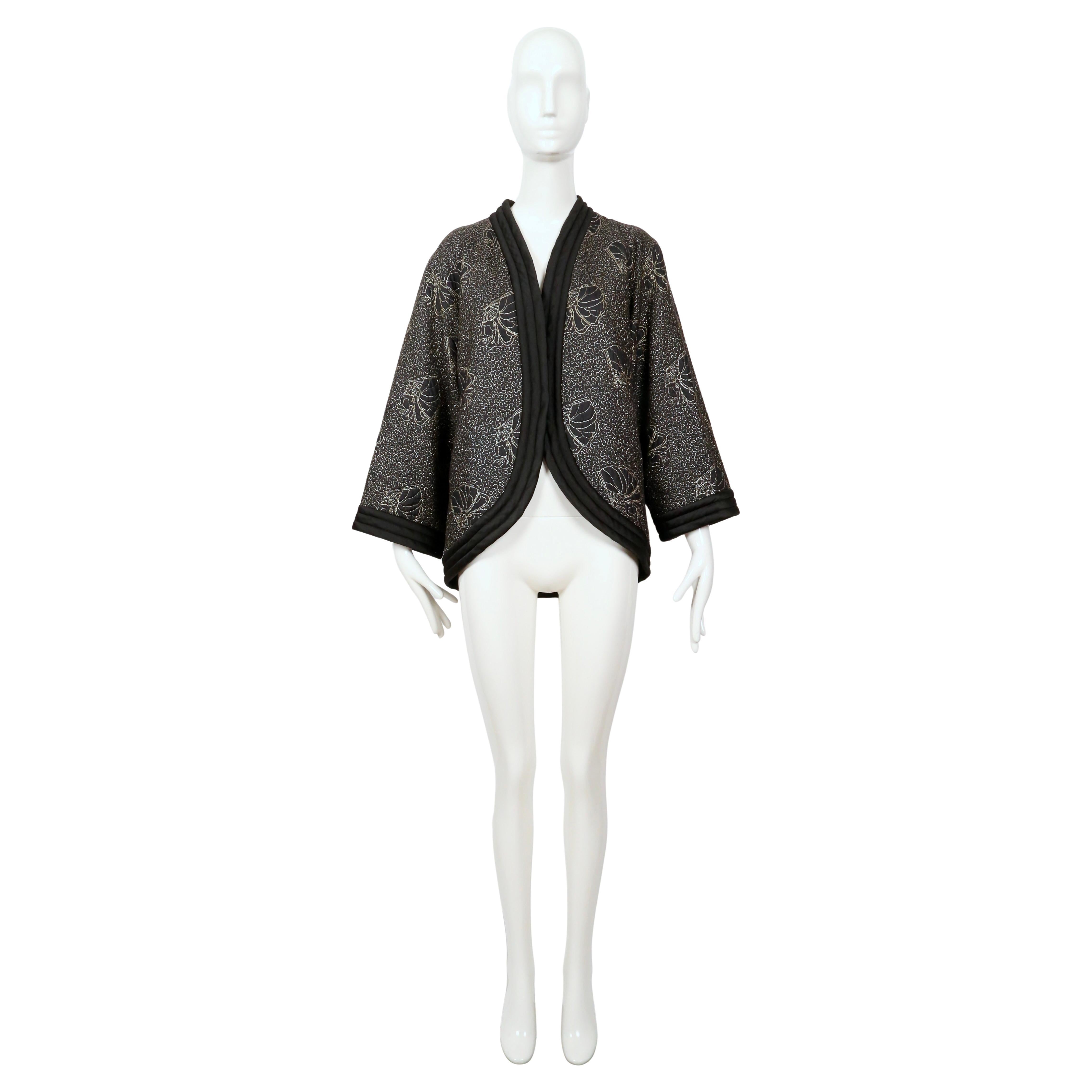 Very rare black, satin kimono jacket with metallic-gold seashell embroidery designed by Yves Saint Laurent dating to 1979. This piece is incredible and even better in person. The gold embroidery has a subtle sparkle and due to the light quilting