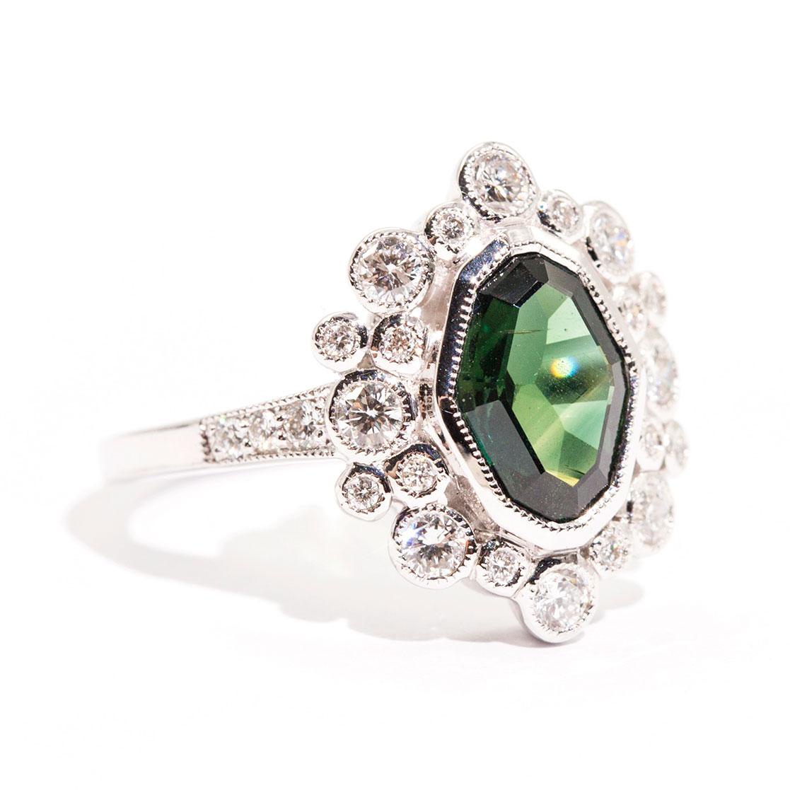 Forged in 18 carat white gold is this alluring art deco and vintage inspired ring that features a 1.98 carat mix cut natural sapphire of a bright deep green colour and is encompassed with total of 0.64 carats of bright white round brilliant cut