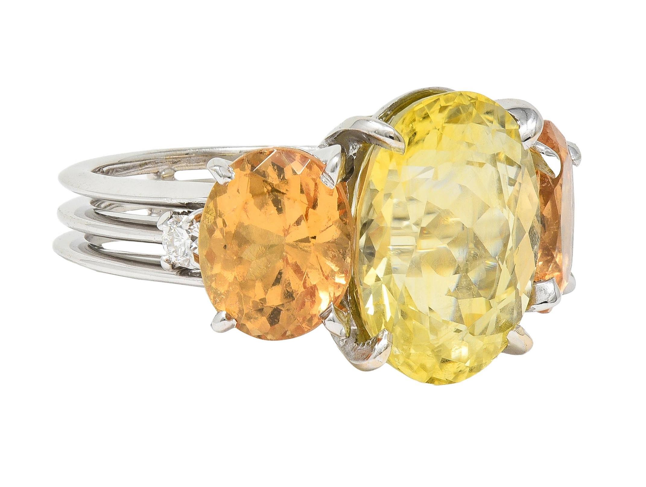 Centering an oval cut sapphire weighing 9.73 carats total - transparent light yellow
Natural Sri Lankan (Ceylon) in origin displaying no indications of heat treatment
Prong set in basket and flanked by oval cut light orange hessonite