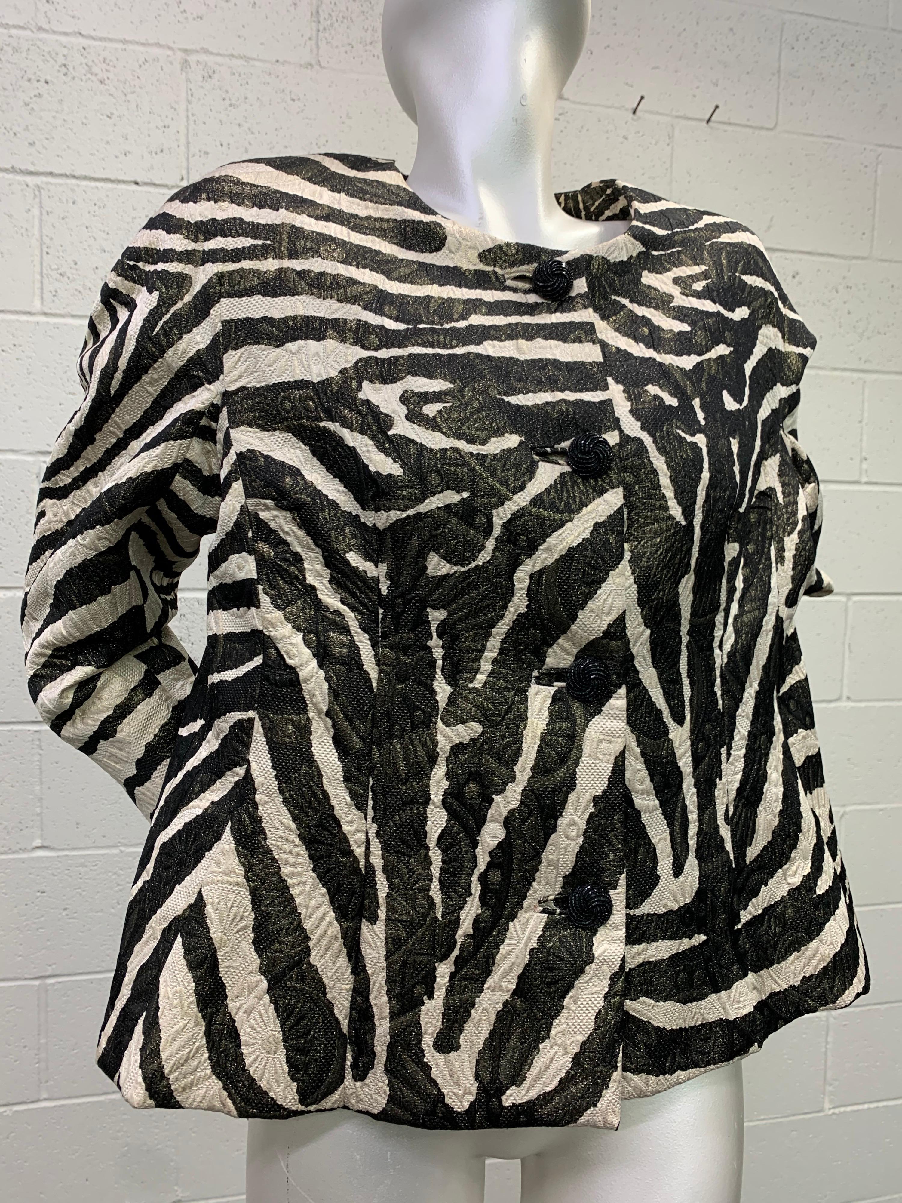 1980s Arnold Scaasi zebra print black and white matelasse brocade boxy jacket:  Collarless, boxy-cut with red silk lining. Back panel utilizes clever pattern paneling to resemble a zebra head at center back. Center back vent. Padded shoulders. Fits
