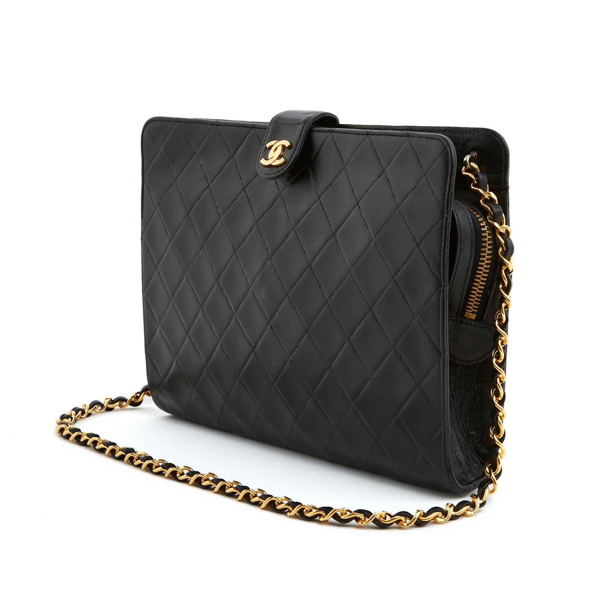 Chanel bag from the Timeless or Classic series, probably Haute Couture, clutch style in quilted black leather, black canvas interior with a zipped pocket, zip closure with CC logo puller in gold metal, leather snap tab decorated with the CC logo,