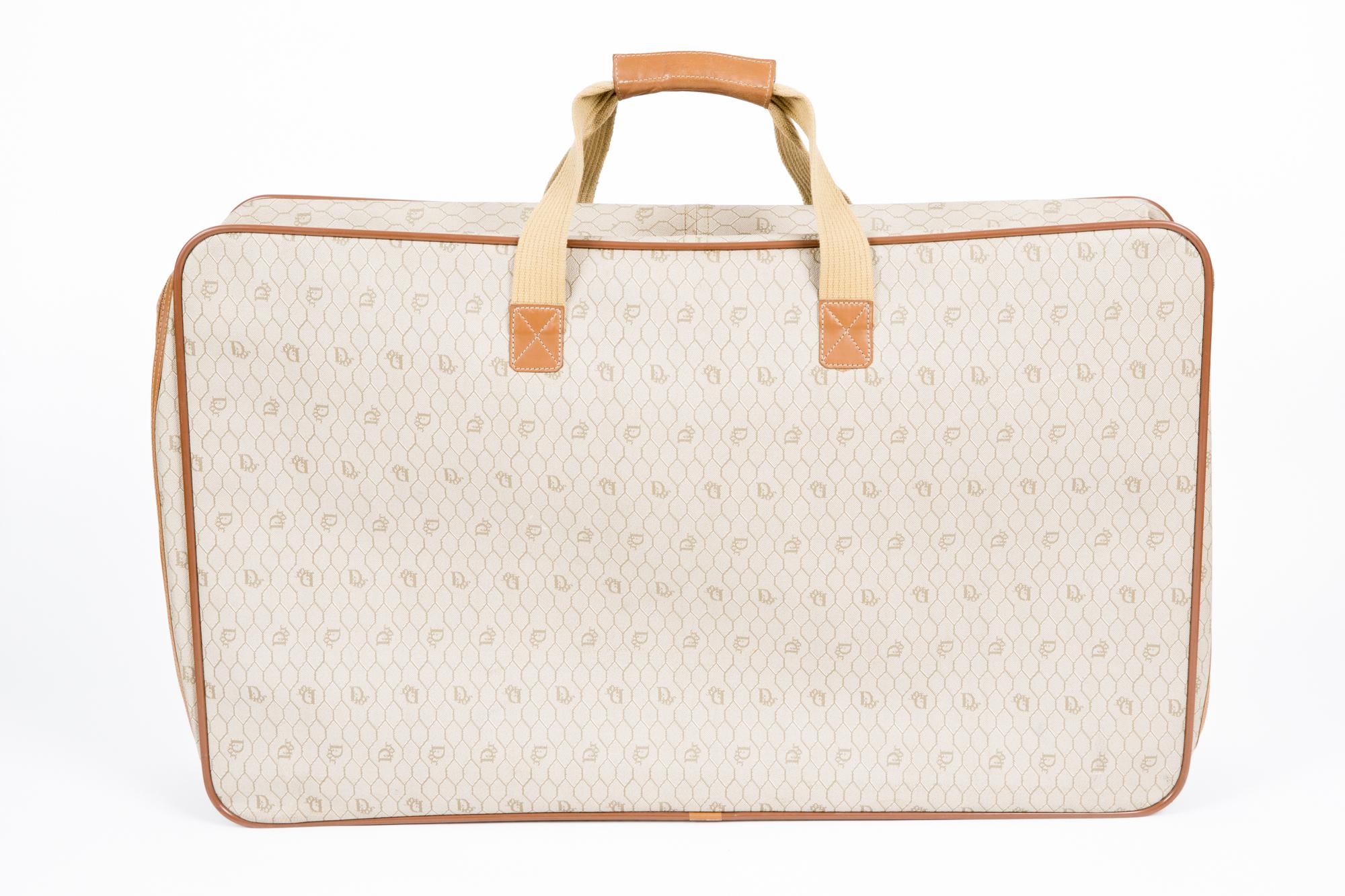 1980s Christian Dior camel cotton canvas monogram suitcase featuring an all over logo pattern, a zip opening, long coton handles (so you can put it on shoulder 19.68in. (49cm) X 1.5in. (4cm)),  inside elastic details, an inside gold tone logo