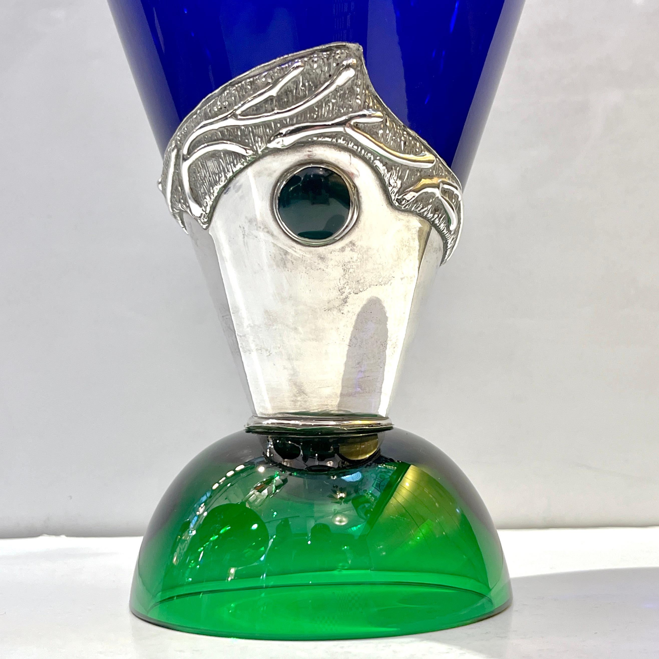 Circa 1980, a vintage bottle and stopper designed with Art Nouveau style in green and cobalt blue glass, the craftsmanship of this item of highest quality with a half-moon vivid emerald green glass cup base that supports a conical dark navy blue
