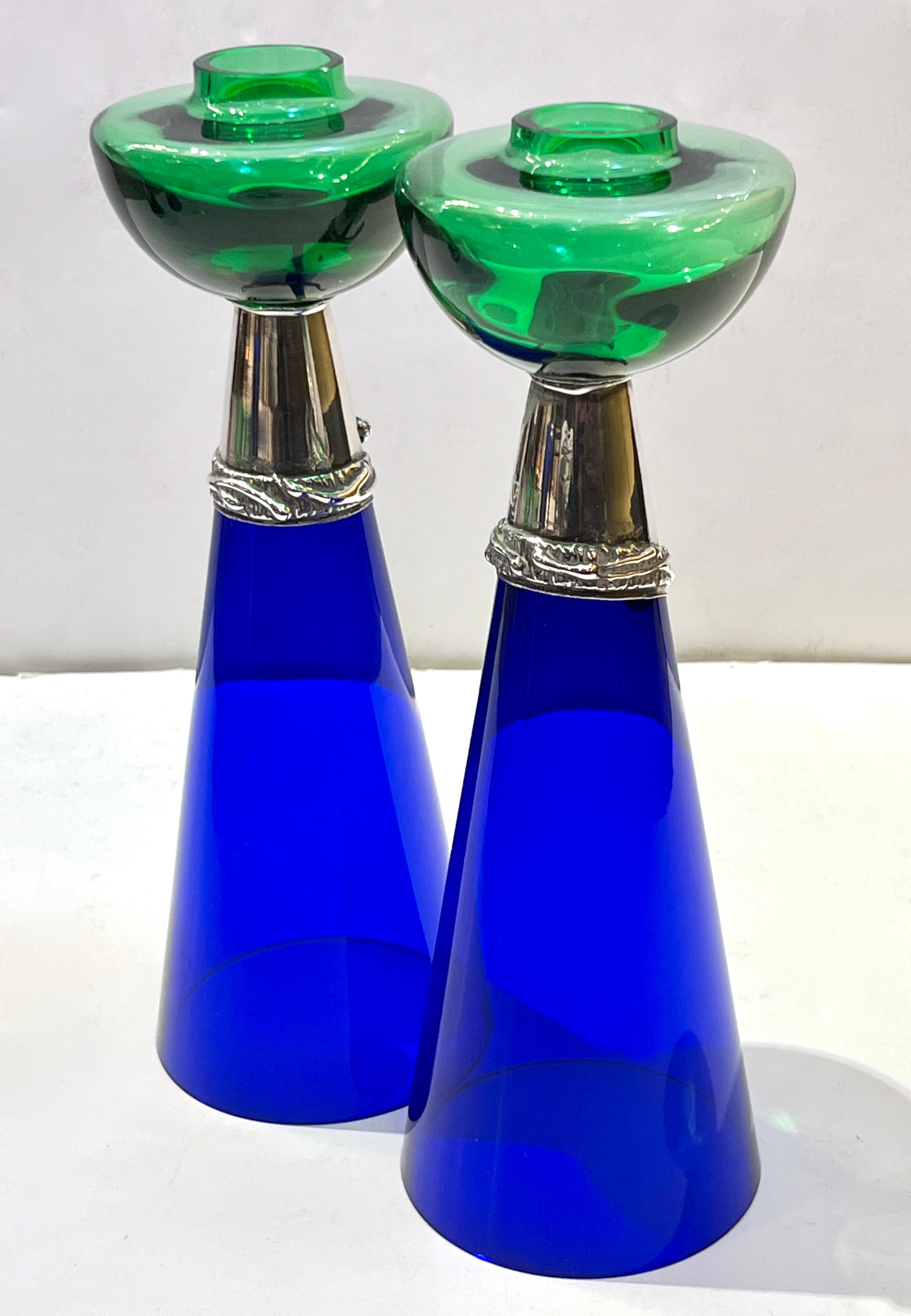 Circa 1980, a vintage pair of candlesticks designed with Art Nouveau style in green and cobalt blue glass, the craftsmanship of this pair is of the highest quality with a conical dark navy blue base that supports a half-moon vivid emerald green