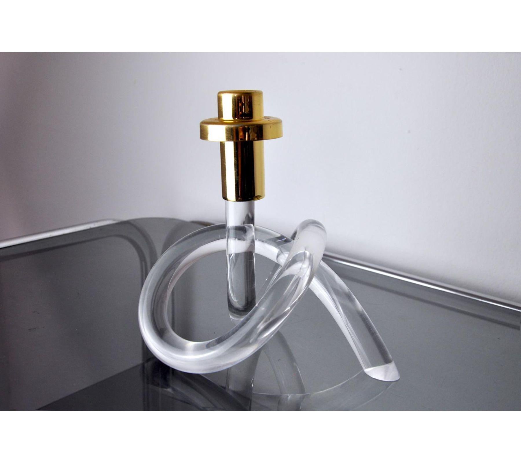 1970s lucite candle holder with golden brass support in the shape of a pretzel designed by elaine bscheider for dorothy thorpe. Superb design and vintage object to decorate your interior. 
 