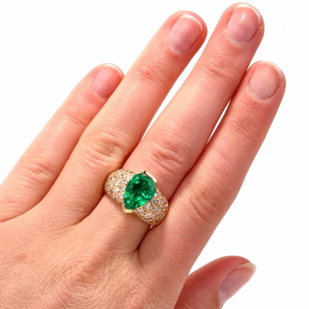 This opulent and timelessly elegant cocktail ring with a 4.01 carat GIA certified brilliant-cut pear shape emerald and pave diamonds is crafted in solid 18-karat yellow gold, weighing 11.42 grams and measuring 14 mm wide. The natural beryl emerald