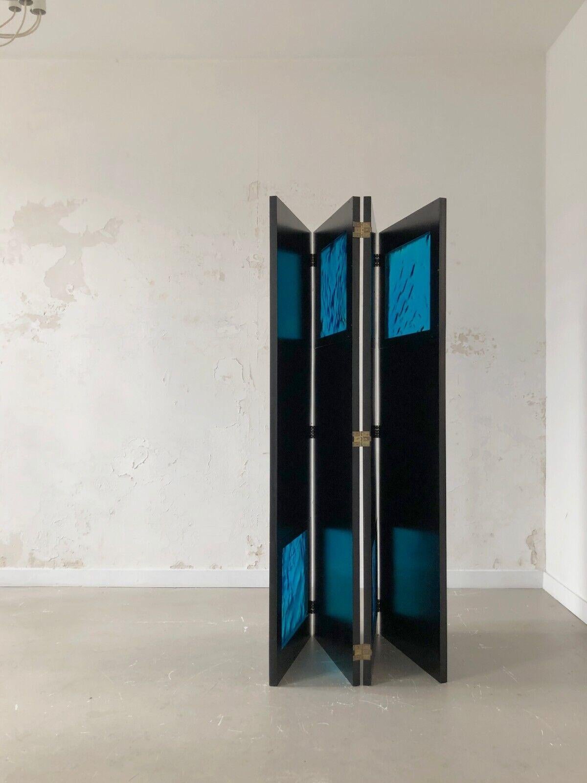 An outstanding, radical, monumental screen with 4 panels in thick black lacquered wood, with 4 exceptional massive turquoise Venini glasses, displayed alternatively at the bottom and at the top of each panel. Every piece of the blown glass is unique