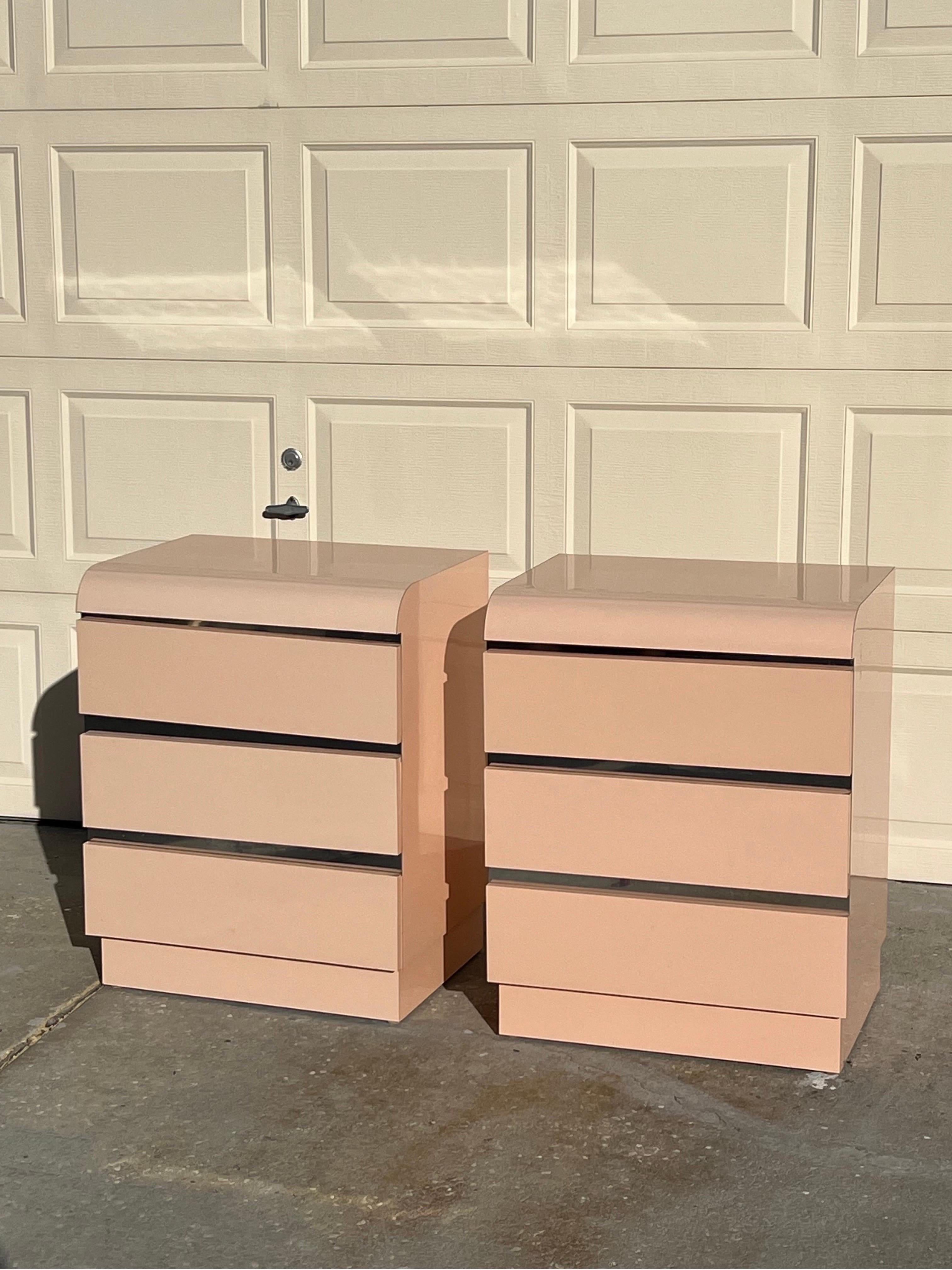 A pair of light pink laminate nightstands, custom made in 1980. The chrome details between the drawers are unique and make this pair extra unusual.