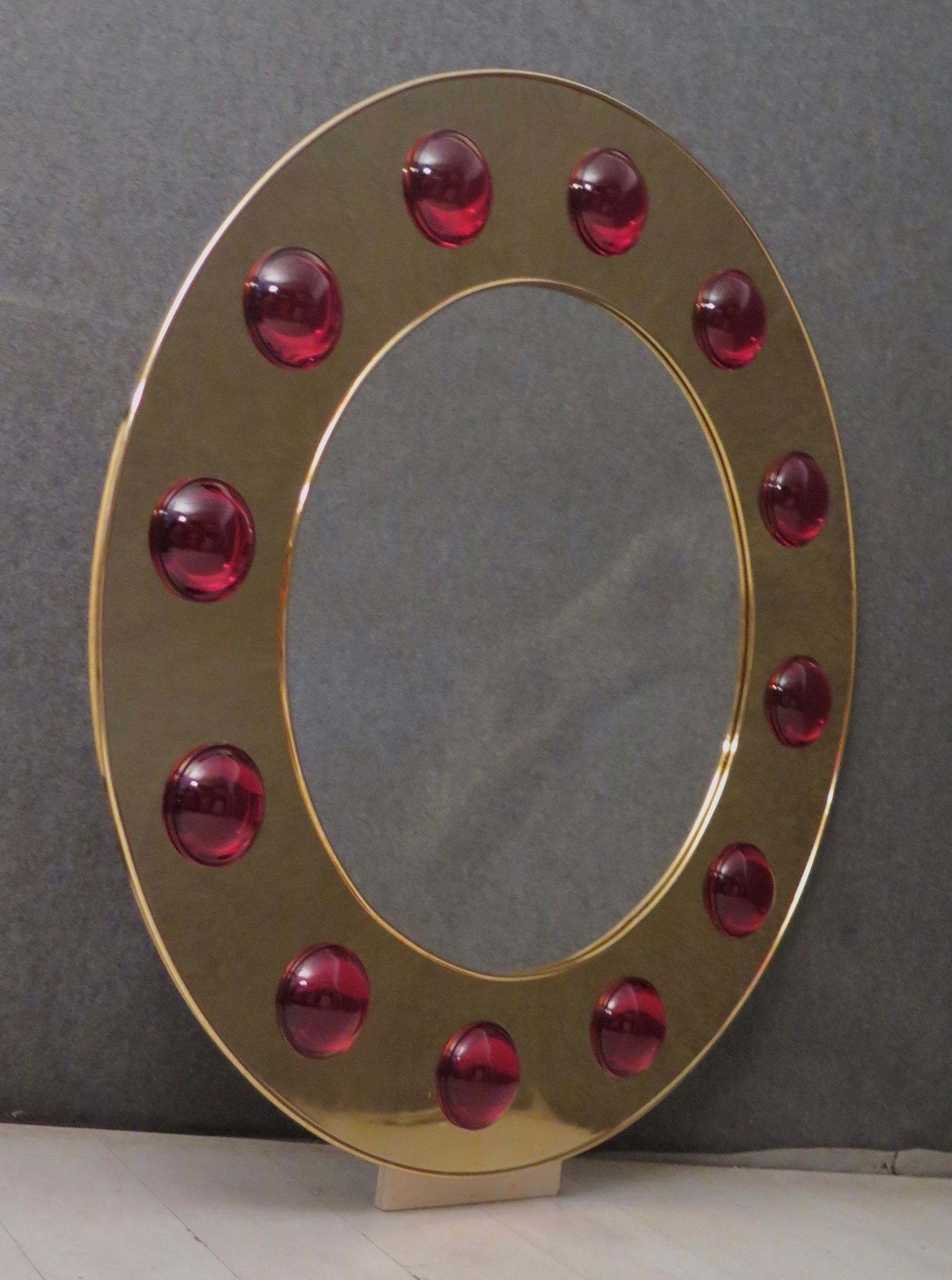 Murano wall mirror in the middle of the last century. This mirror has a very brilliant appearance, due the use of not common materials, brass and Murano glass lenses.

Wooden frame, covered with a brass frame. The frame has a rounded edge, both