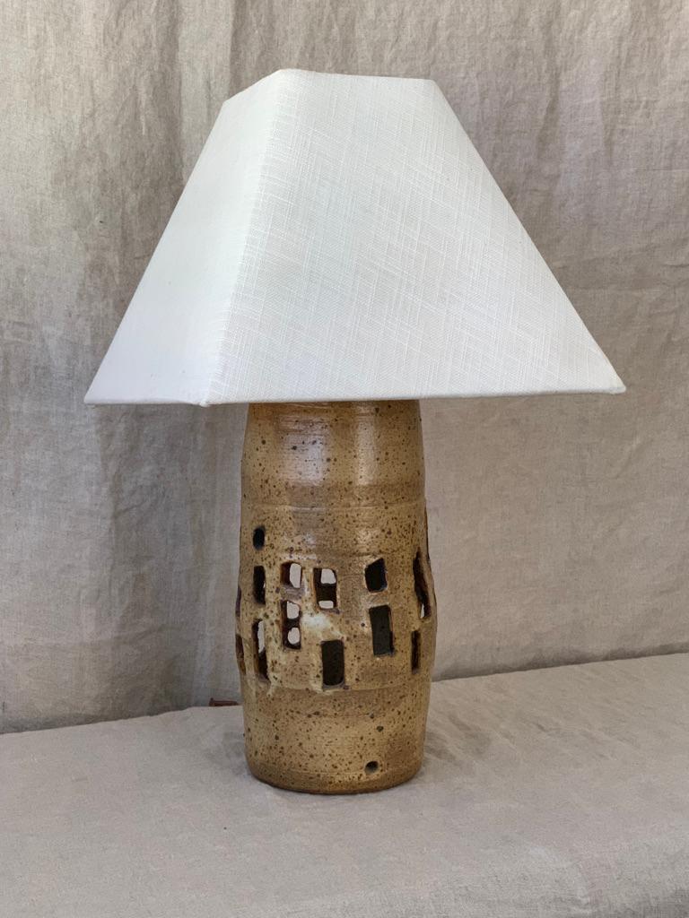 A 1900's table lamp by ceramic pottery artist. Crafted from clay, it has been shaped and carved in a way to function as a work of art, whether turned on or off. 

Dated and signed by artist.

