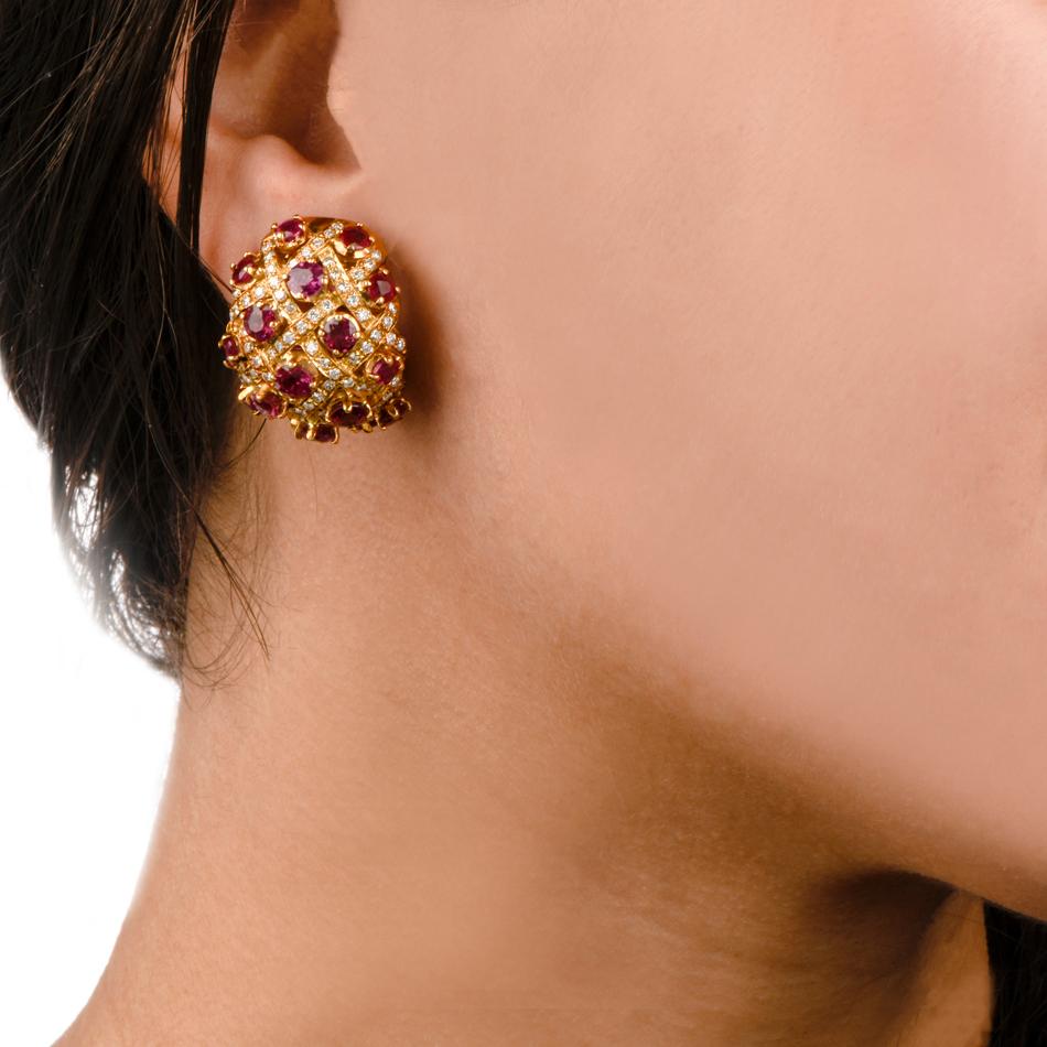 These Vintage Retro clip-on earrings with rubies and diamonds are crafted in solid 18-karat yellow gold, weighing 31.2 grams , and measuring 25 mm long x 23 mm wide. Designed as vividly colored, convex plaques, the earrings are adorned with a total