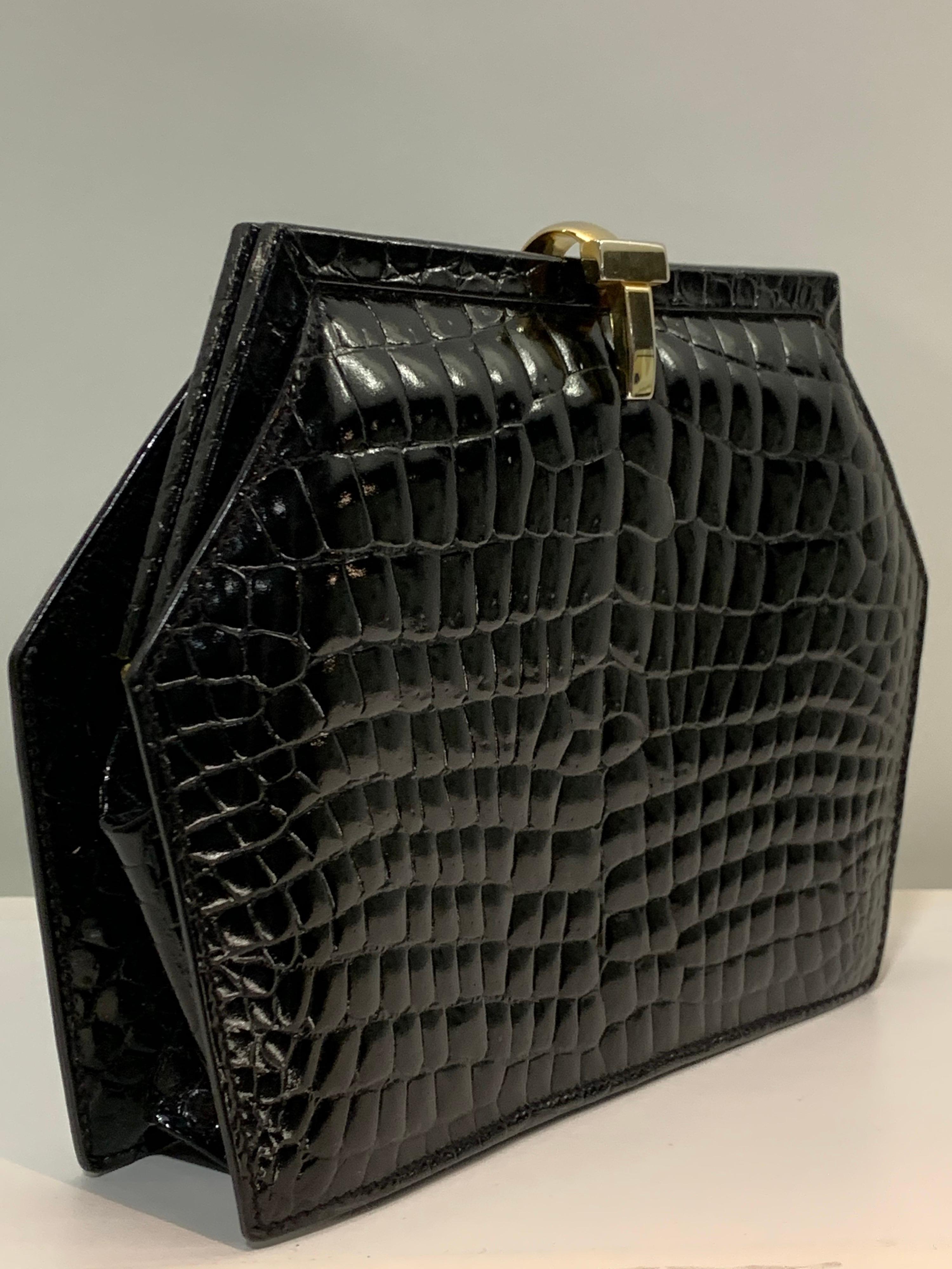 A stunning 1980s Tiffany & Co black alligator 6-sided trapezoid shaped clutch handbag. Made in Italy. Gold-toned clasp. Leather interior. An absolute classic! 