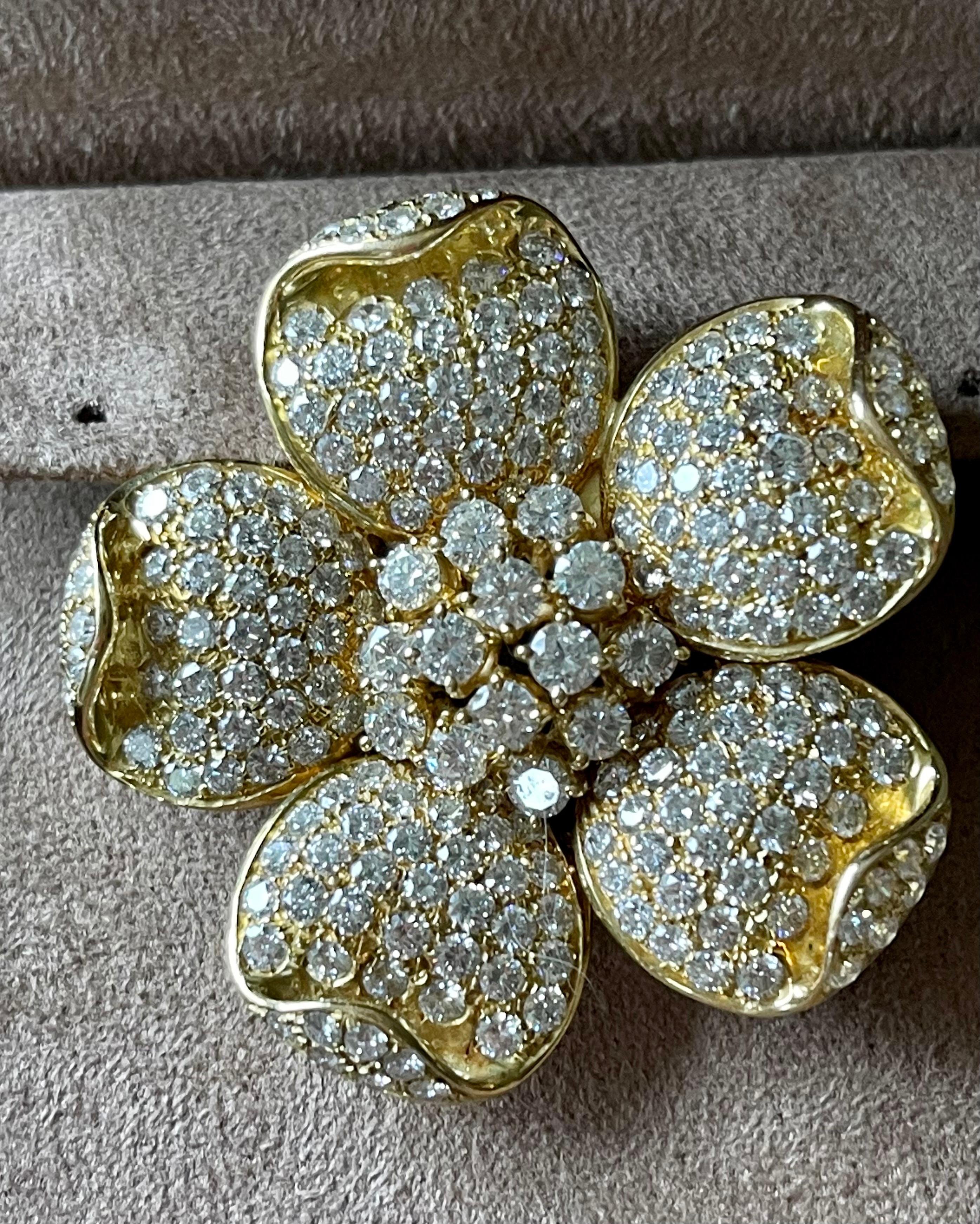 This aesthetically fascinating and immaculately crafted lapel brooch is designed as a captivating flower, rendered in solid 18 K yellow and white Gold.  Exuding astonishing glitter, this exquisite monochromatic piece of jewelry is centered with 14
