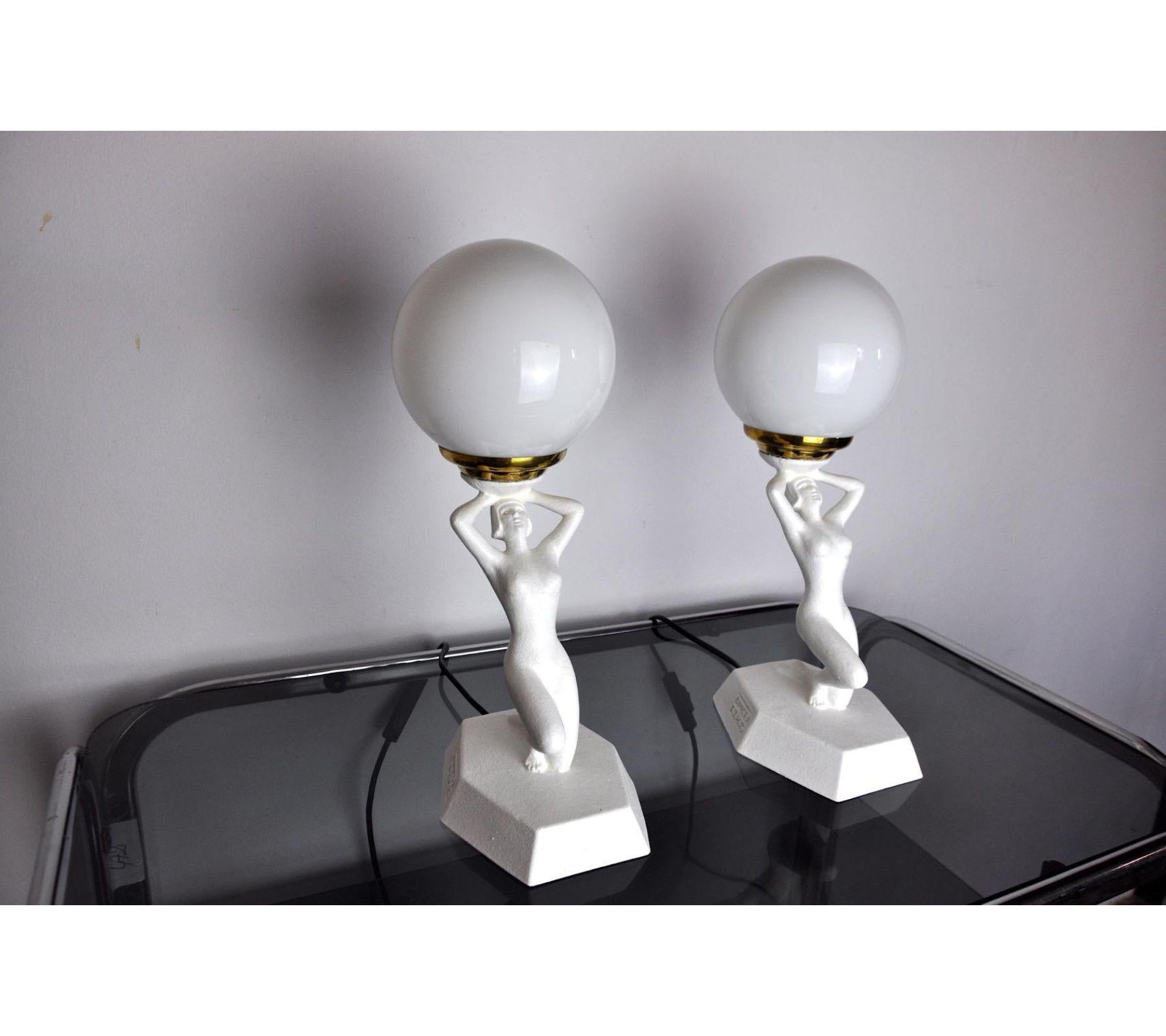 Very nice pair of art deco table lamps signed onice eth representing a woman playing ball, designated and produced in the 1980s. Resin lamps and platre painted white and its opaline globe in perfect condition. This design object will illuminate your