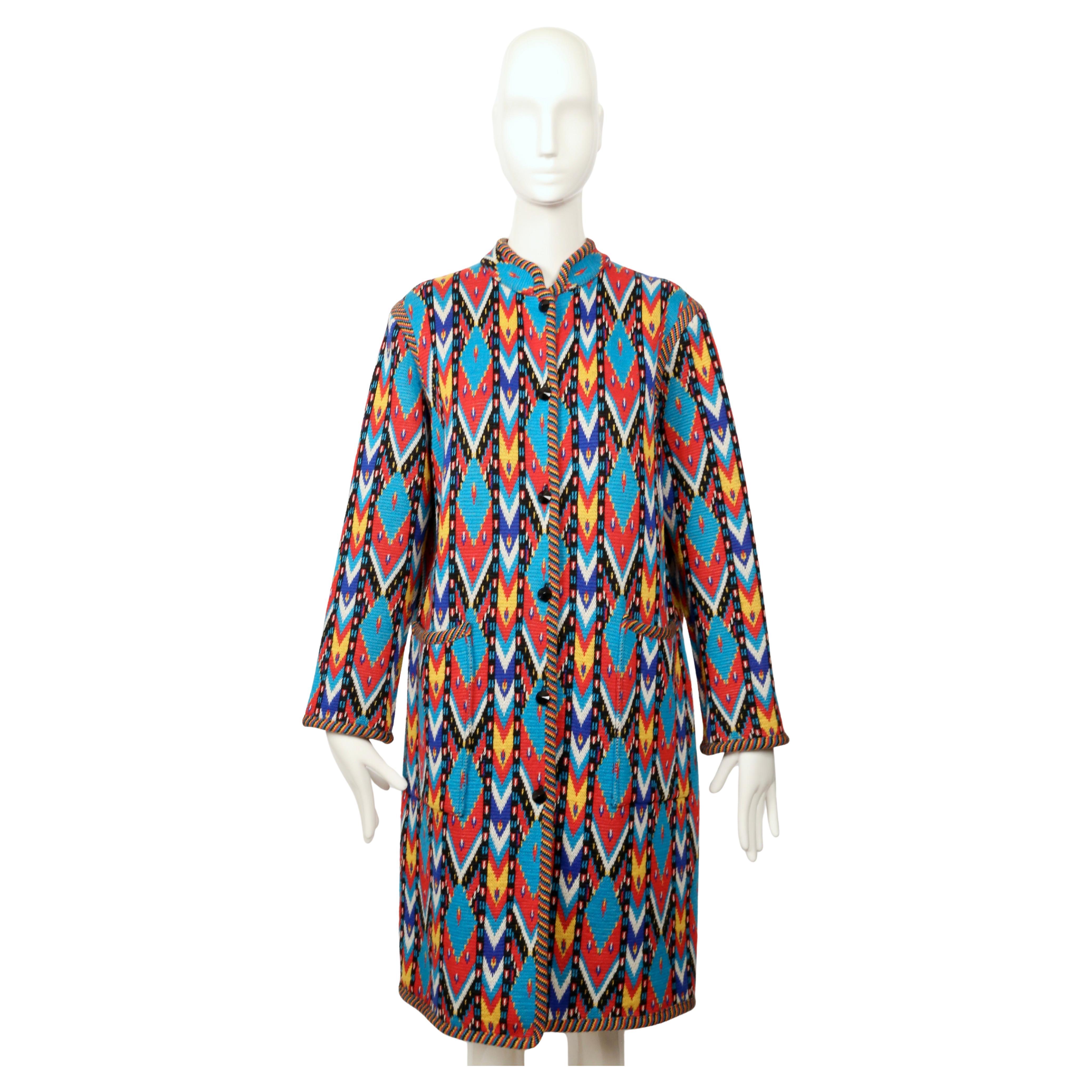 Ce pull-over vibrant, présenté lors du défilé d'Yves Saint Laurent en 1980, est un exemple frappant de son amour pour les couleurs vives et les textiles d'inspiration mondiale. Réalisé dans un tricot richement tissé, il présente un motif ikat
