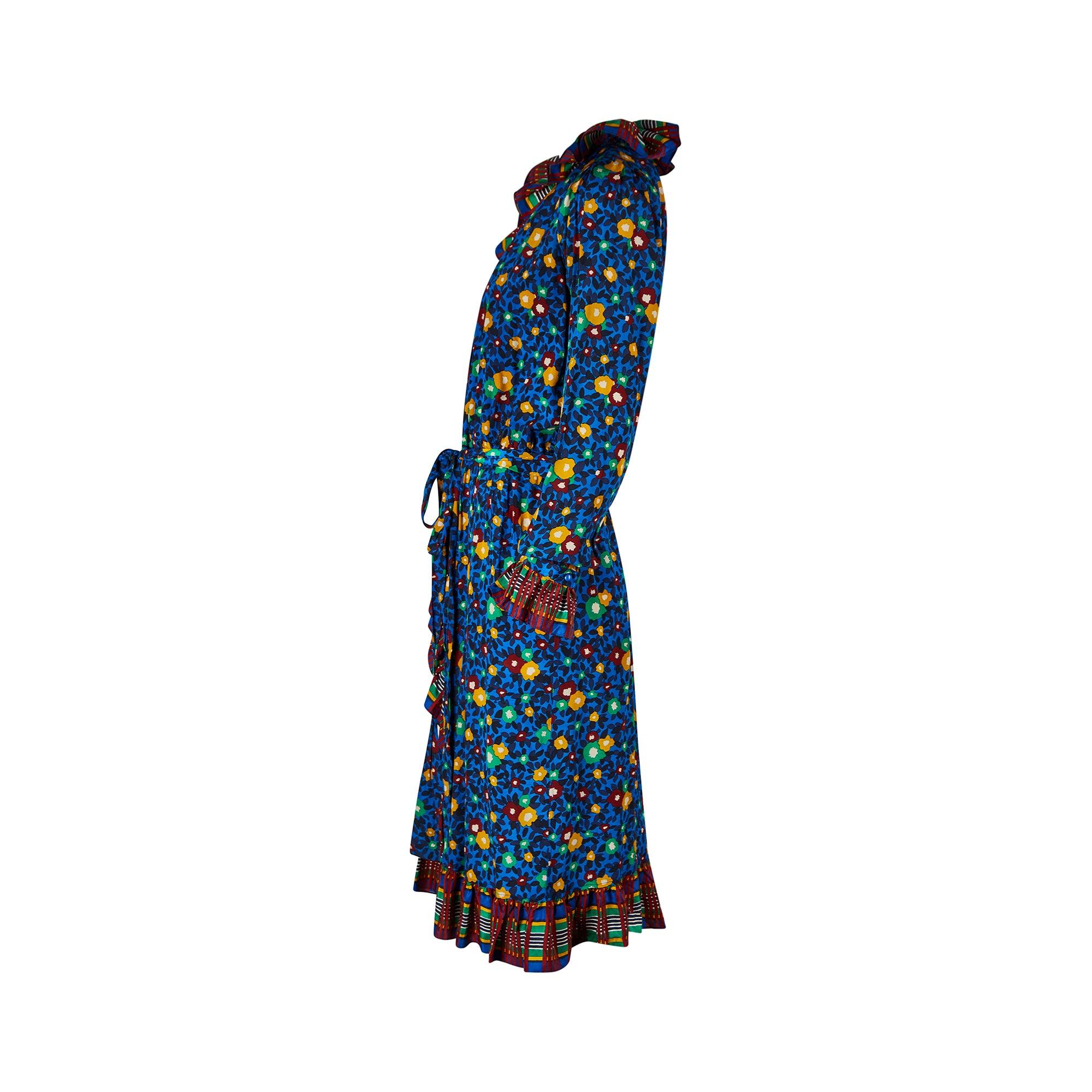 Dieses vom Laufsteg dokumentierte Seiden-Wickelkleid stammt aus der Frühjahr/Sommer-Kollektion 1980 von Yves Saint Laurent. Der malerische Blumendruck wird durch ein Karo an Kragen, Manschetten und Saum kontrastiert, die allesamt dekadent gerafft