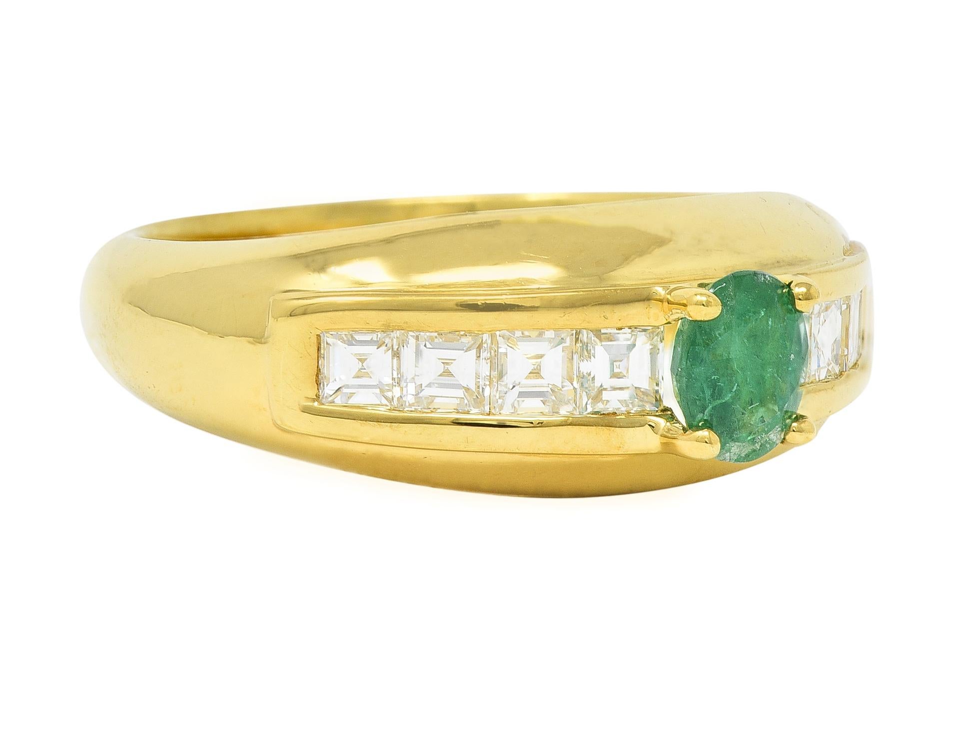 Centering an oval cut emerald weighing 0.38 carat total 
Transparent medium green in color - prong set
Flanked by rows of square step-cut diamonds 
Channel set and weighing 0.62 carat total 
G/H color with VS2 clarity
Completed by high polish