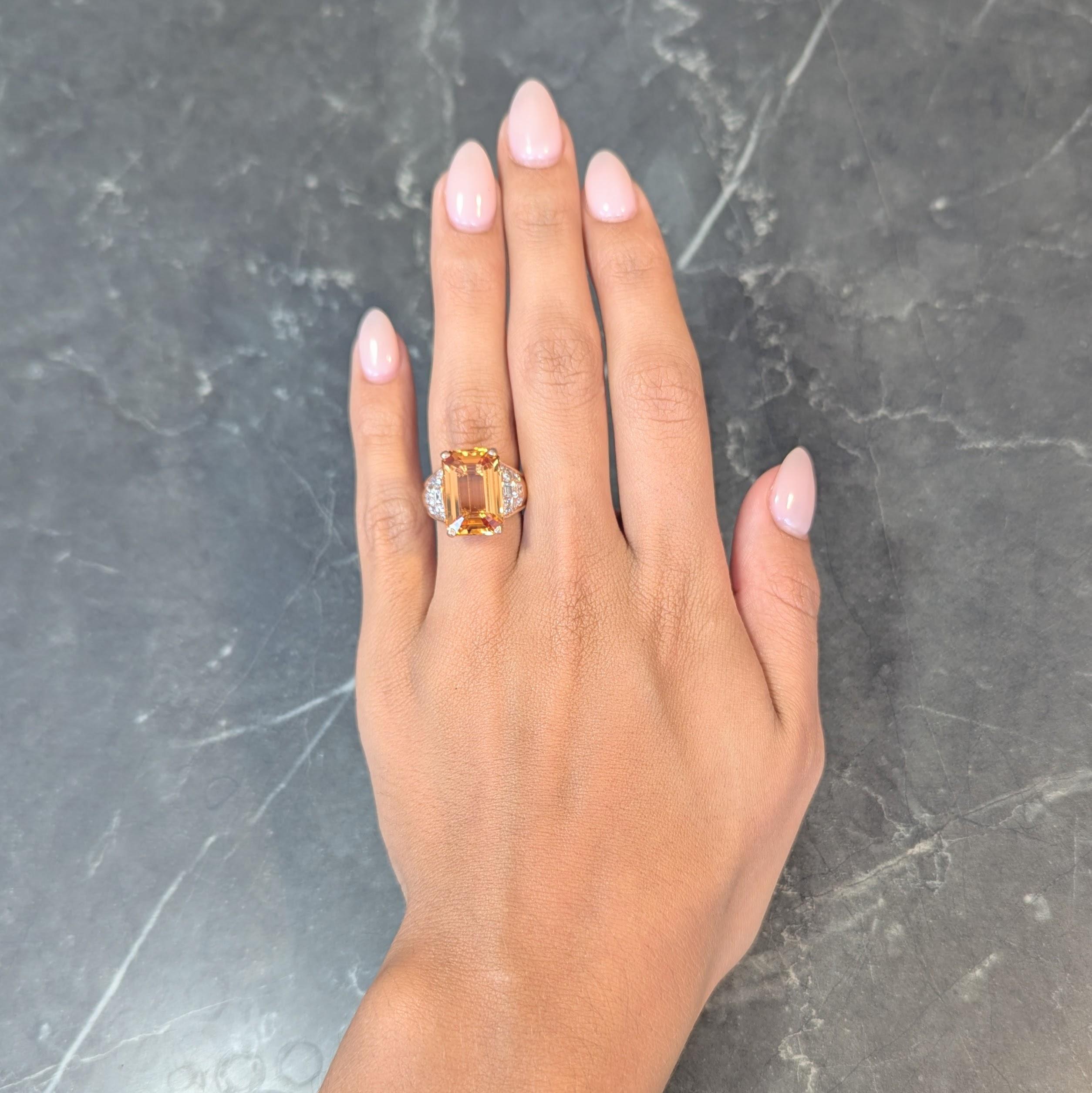 Centering and emerald cut topaz weighing approximately 11.55 carats 
Transparent medium orange in color and prong set in basket
Flanked by cathedral shoulders bead and bar set with diamonds 
Weighing approximately 0.35 carat total
G/H color with VS2