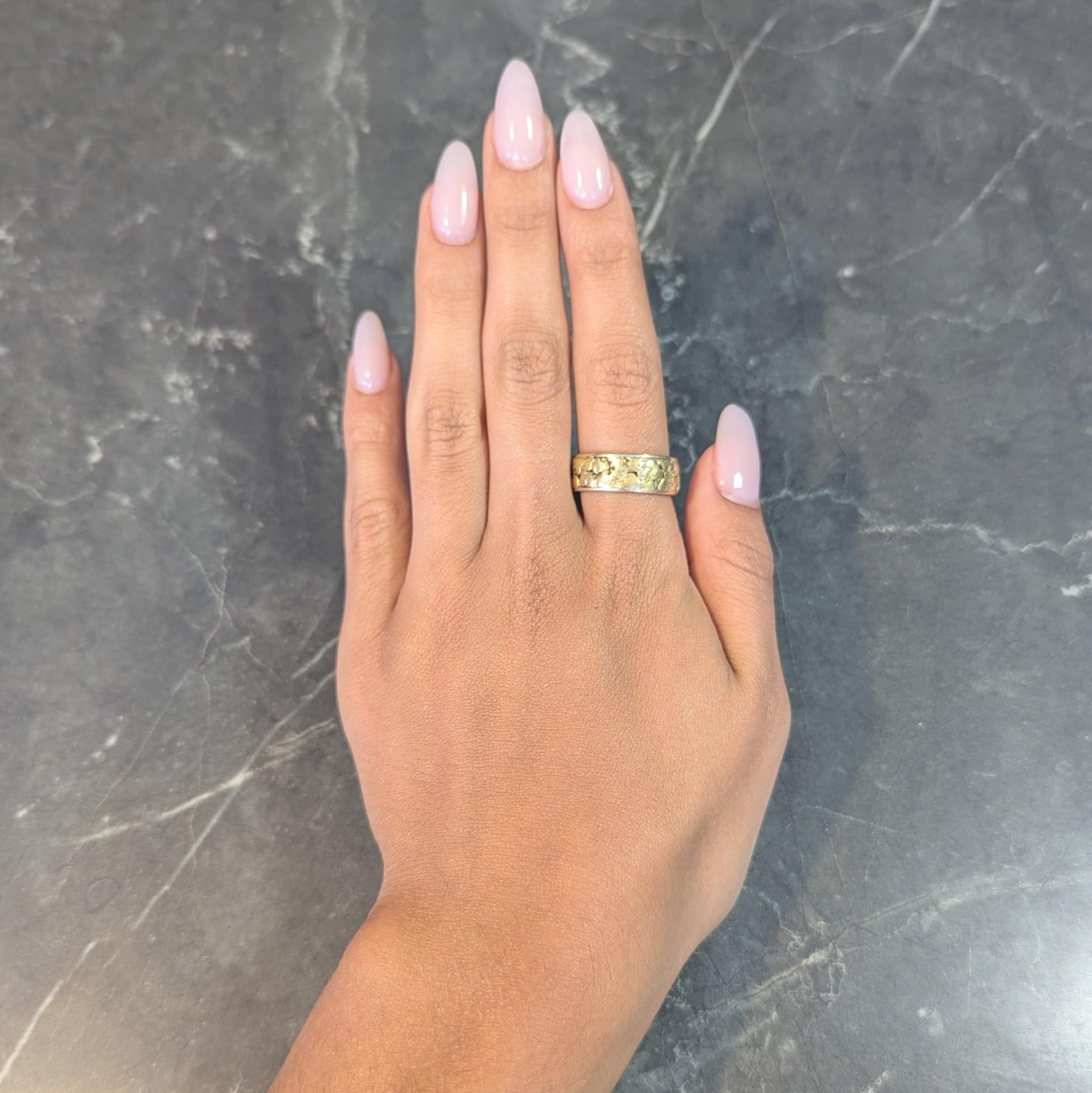 Designed as a band ring featuring gold nugget texture fully around
Organically shaped and flanked by sleek edges
Complete with high polish finish
Gold nugget tests as 18 karat gold
Band is stamped for 14 karat gold 
With maker's mark
Circa:
