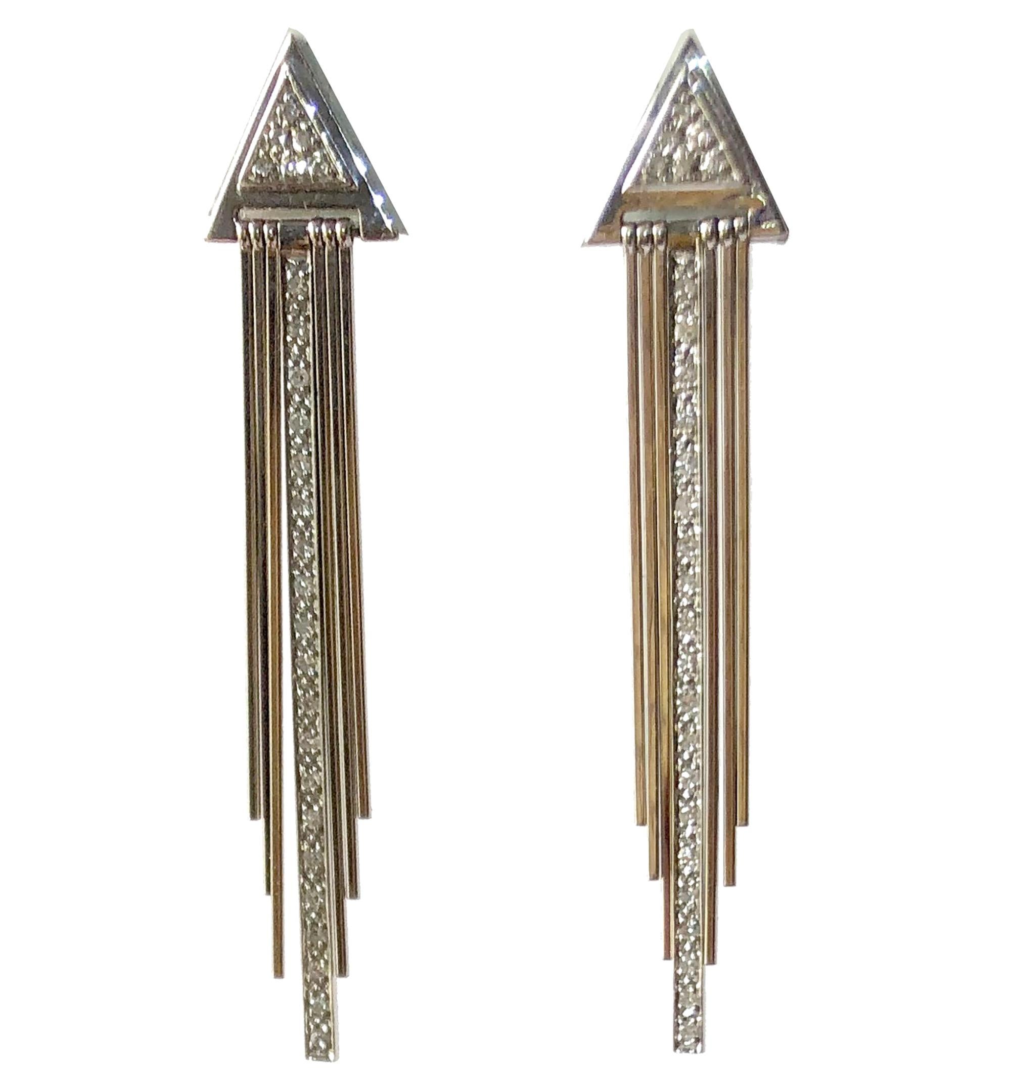 Pair of 14K white gold and diamond fringed 1970's / 1980's Deco revival earrings.  Earrings have a total of seven kinetic fringe, including a strand of diamonds seen center.  Pierced earrings measure 2 3/8