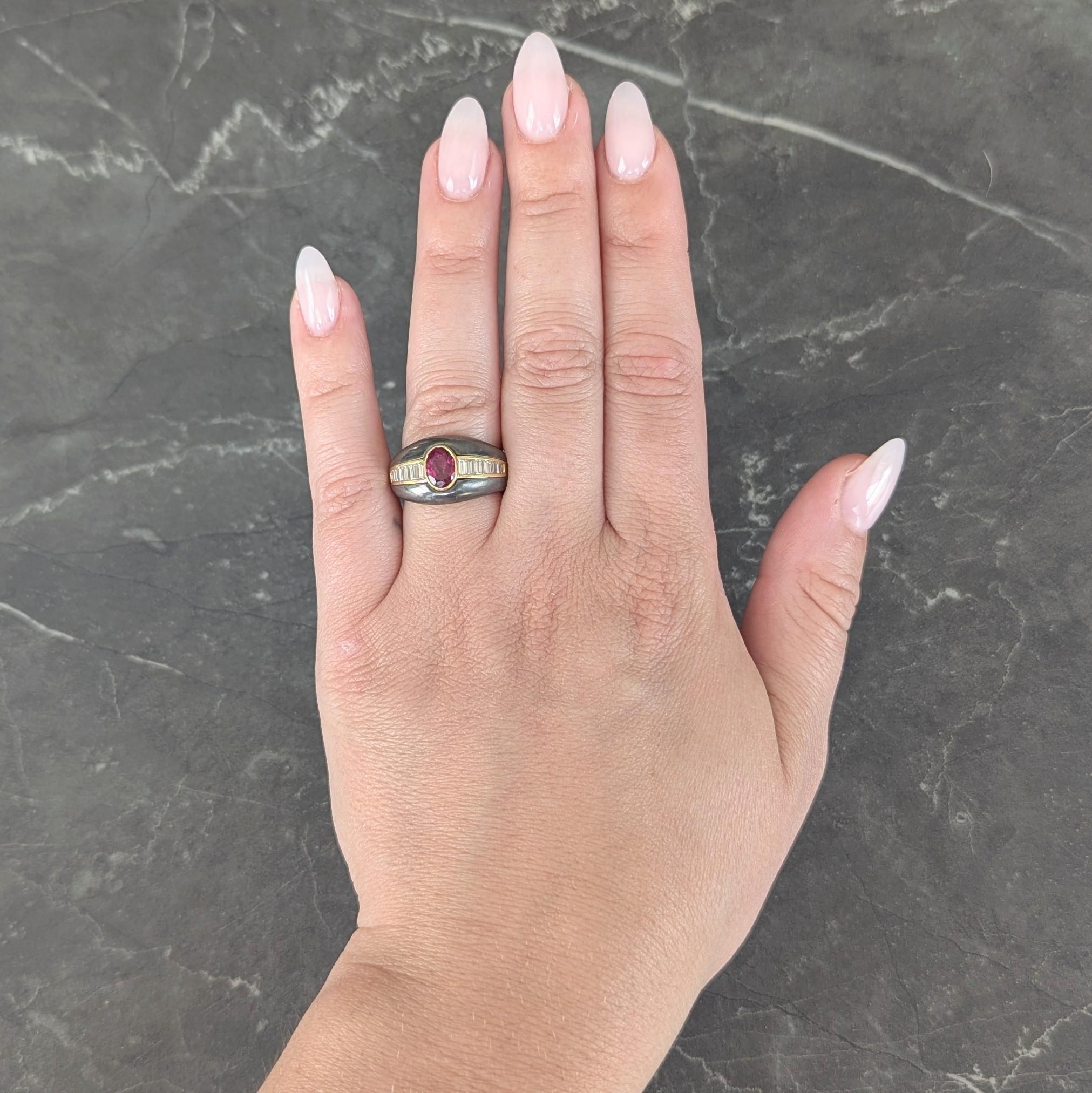 Designed a a bombé shaped ring carved from metallic gray hematite and centering an oval cut ruby
Weighing 0.92 carat - transparent medium red in color and set in a yellow gold bezel
Flanked by graduated baguette cut diamonds channel set in