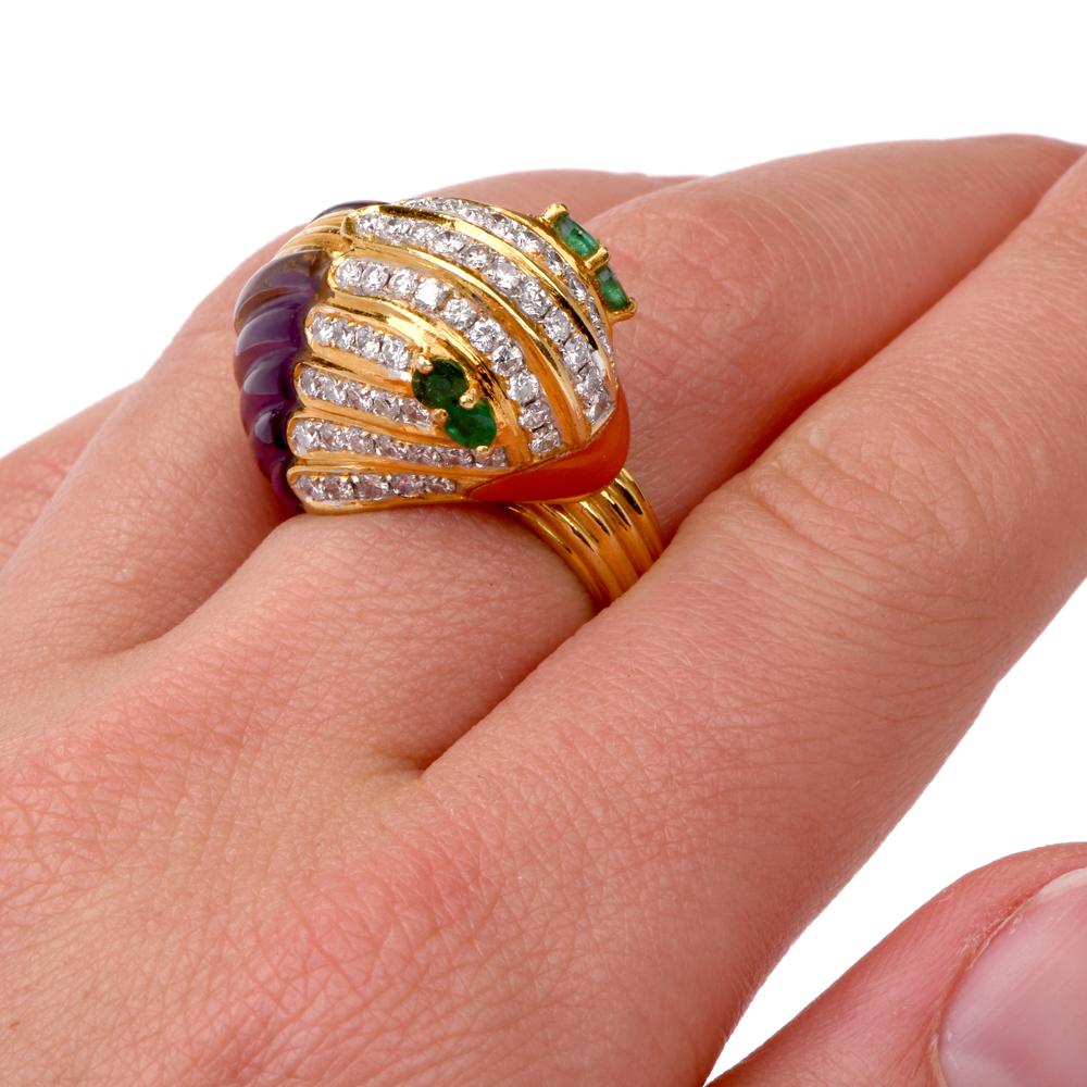 This vividly colored estate cocktail ring depicts a stylized mysterious animal head (bird or fish) rendered in 18 karat yellow gold and adorned with a amethyst for its body, salmon coral beak, emerald eyes and diamond head.  The diamonds weigh 1.00