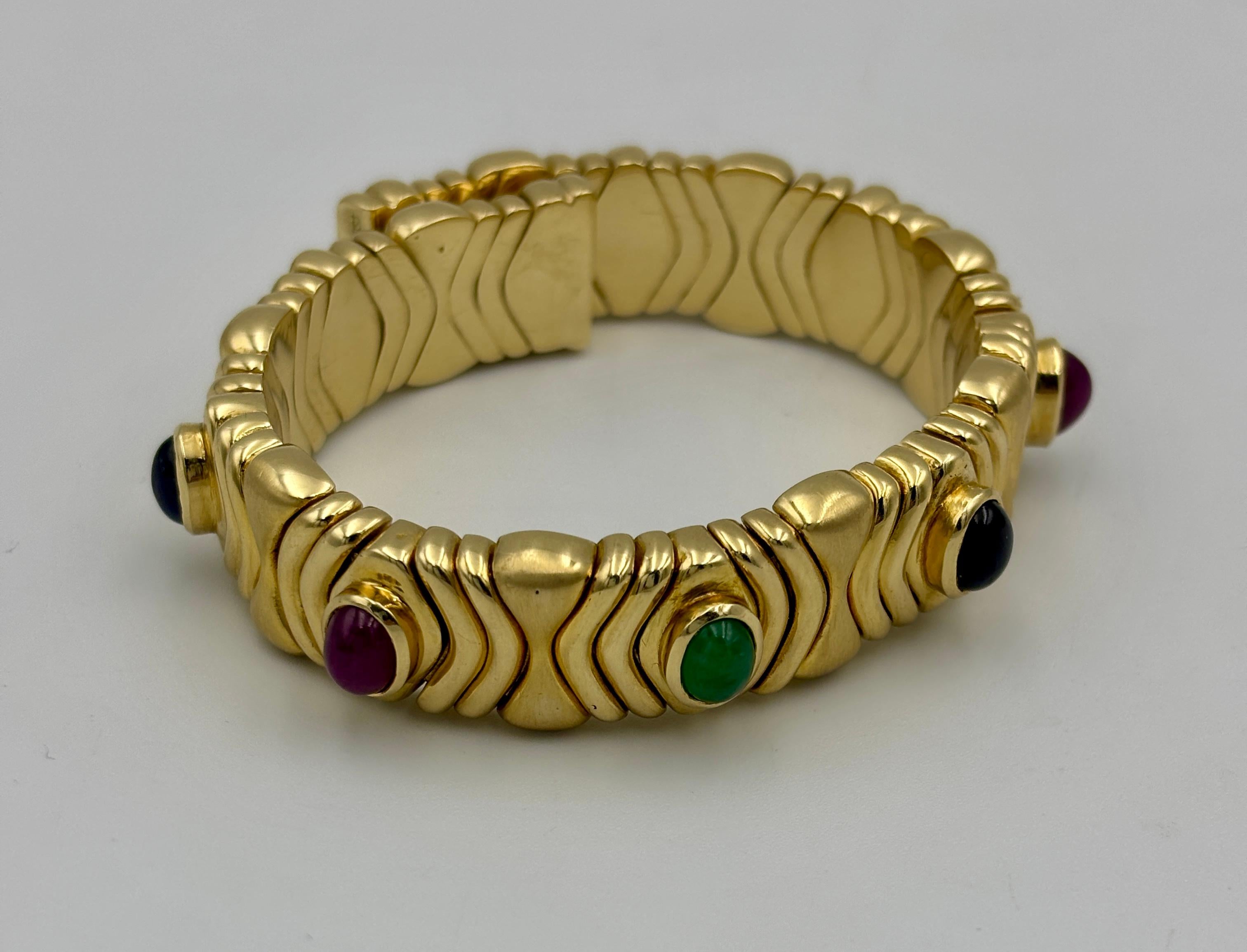 Cabochon 1980s 18k gold Bulgari bangle with ruby, sapphire and emerald For Sale