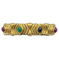 1980s 18k gold Bulgari bangle with ruby, sapphire and emerald