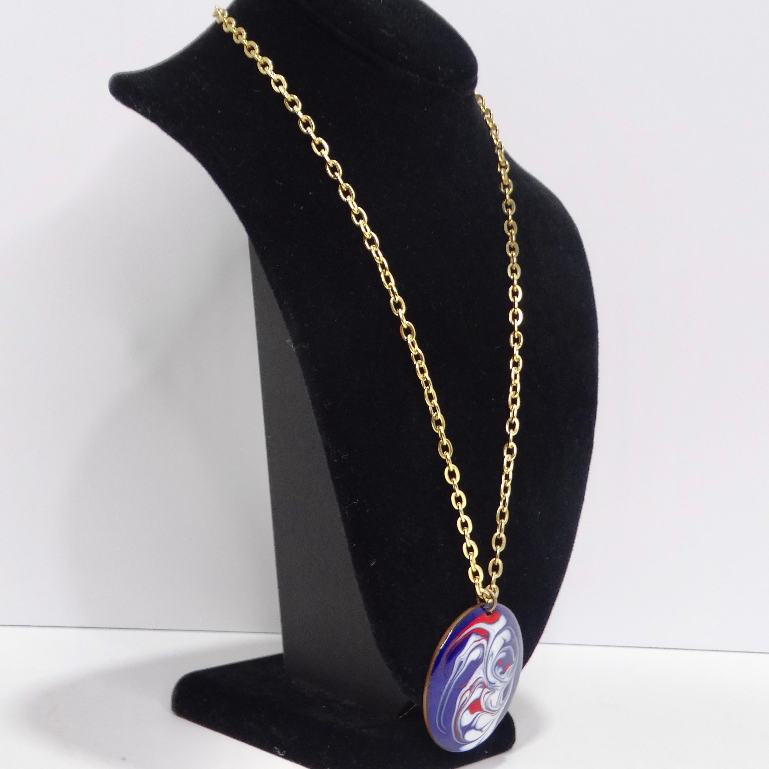 Embrace vintage charm with this 1980s 18K Gold-Plated Blue Marble Pendant Necklace. This classic gold-tone chain necklace showcases a bold circular pendant with a captivating red, white, and blue marble effect. A true statement piece from the 80s,