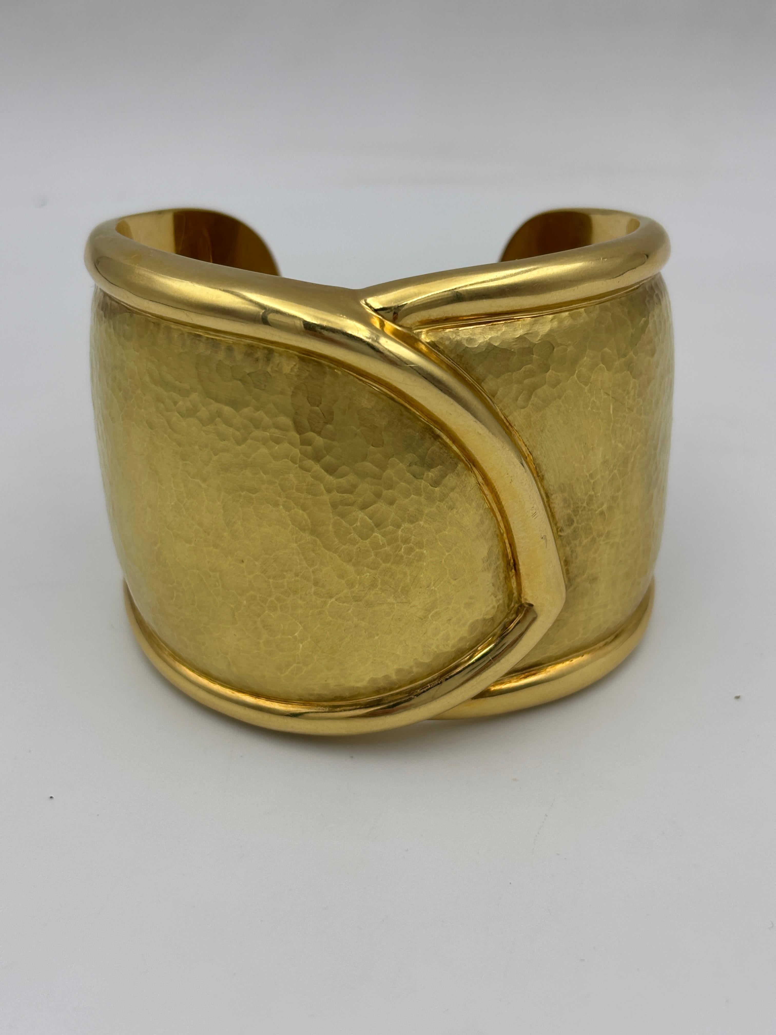 This beautiful 18k gold hand made cuff has a hammered texture. Though chunky in appearance it is rather lightweight and most  comfortable to wear. 54mm in width the cuff has a circumference of 19cm.