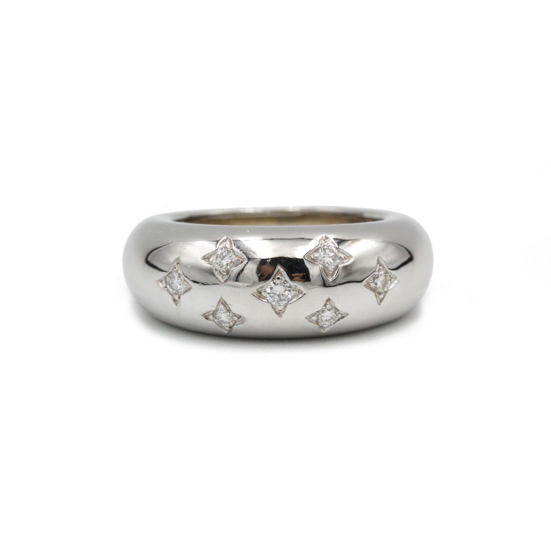 This vintage 1980s band ring is crafted in solid 18K white gold and designed with a smooth, domed “jonc” profile that gives it a bold, sculptural presence on the hand. The surface is decorated with several small diamonds set in star-shaped settings,