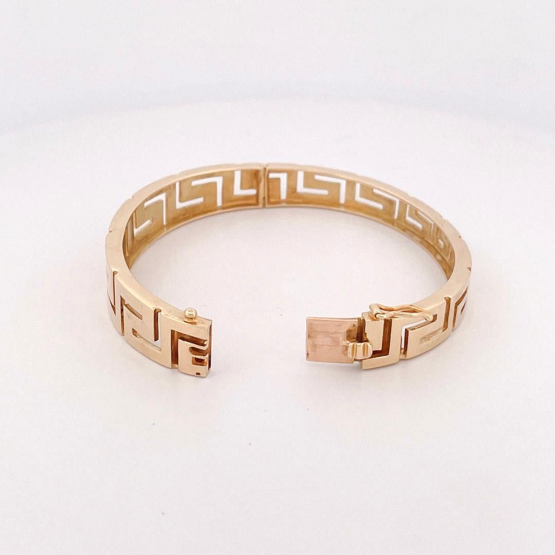 From the Eiseman Estate Jewelry Collection, circa 1980s, 18 karat yellow gold Greek key bangle. This bangle is crafted with high polished Greek key designs and a figure eight safety closure.