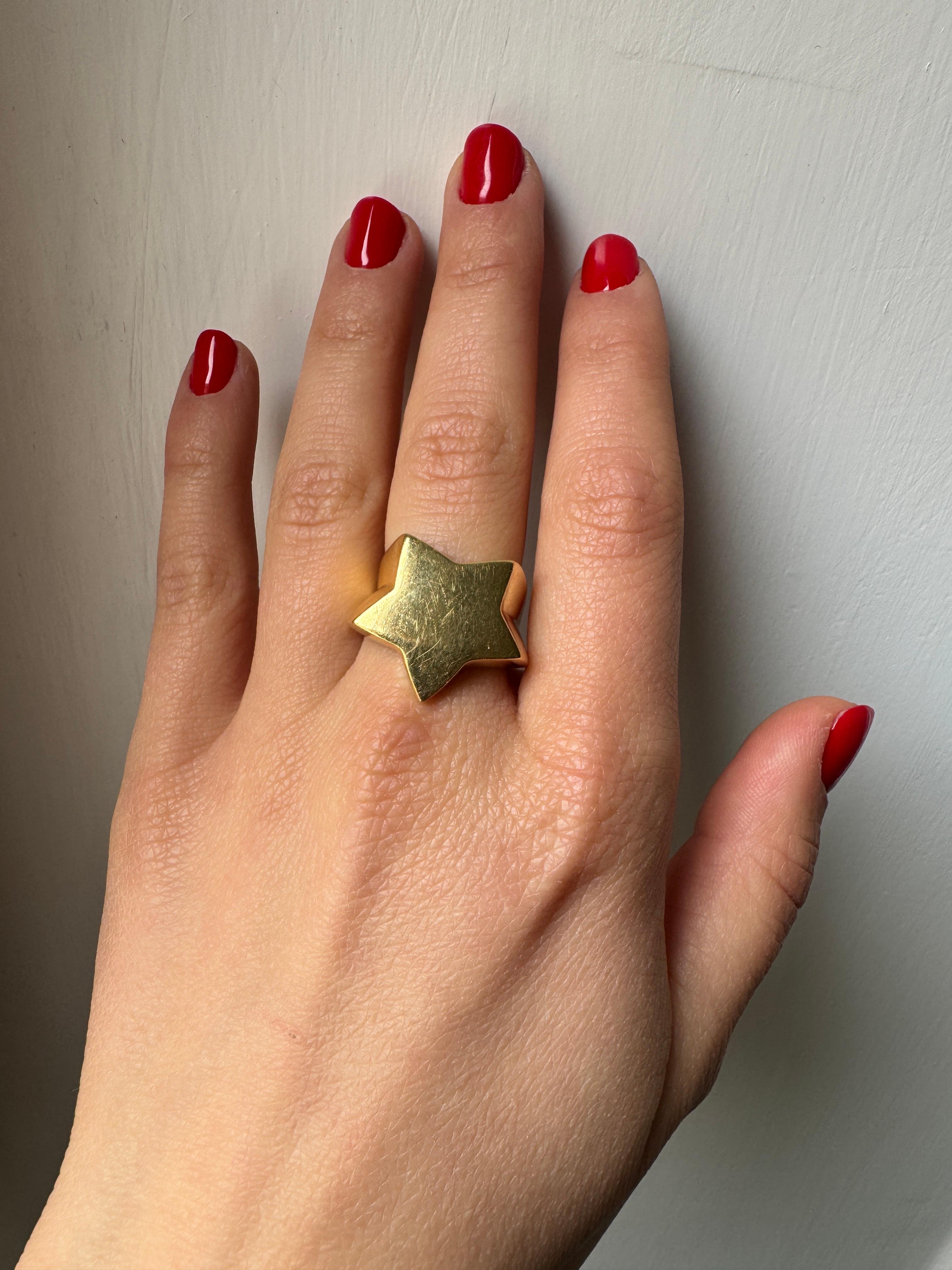 Il s'agit d'une bague unisexe en or jaune 18K des années 1980, non signée, avec un anneau en forme d'étoile, fabriquée en Italie. Retournez dans les années 1980 avec ce design unique en forme d'étoile, où la bande s'enroule élégamment autour du