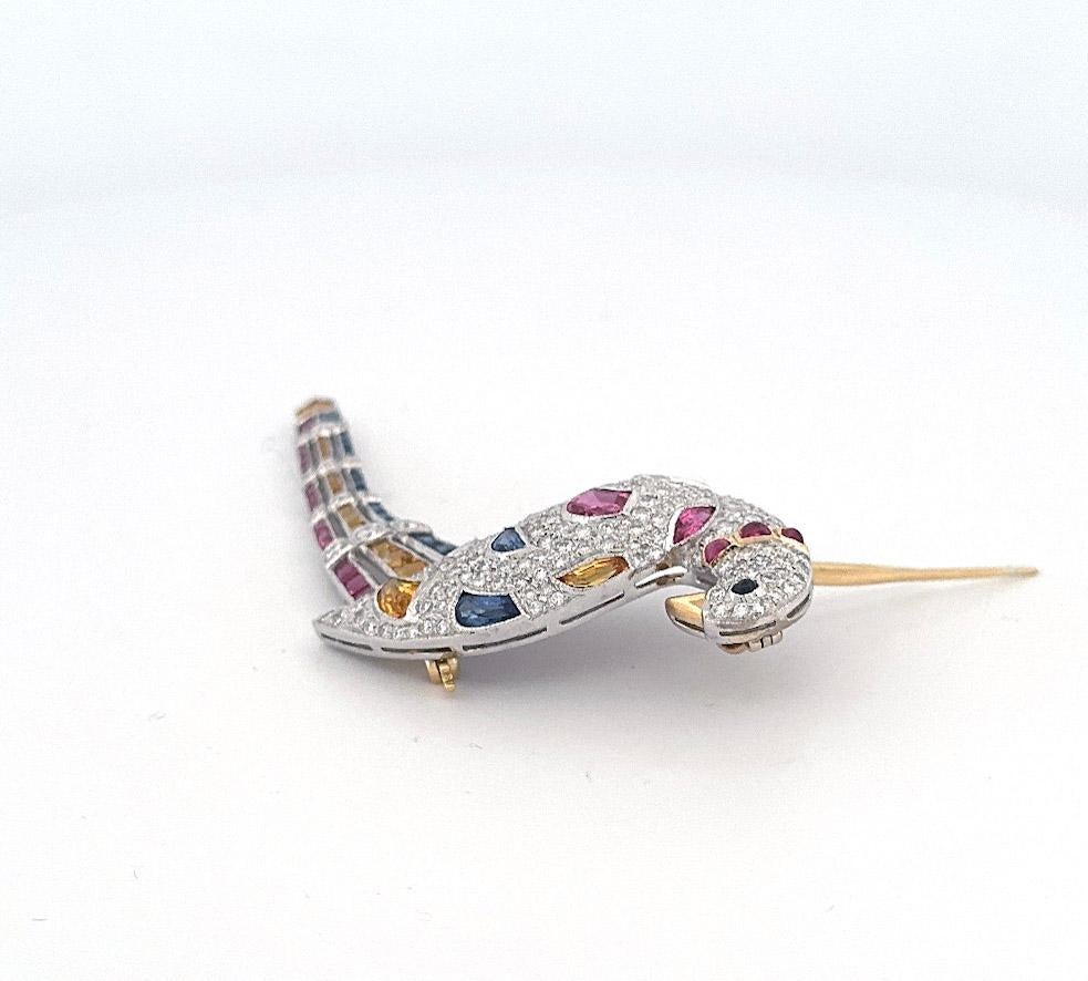 From the Eiseman Estate Jewelry Collection, circa 1980s, 18 karat yellow and white diamond and sapphire bird pin. This pin is crafted with an assortment of colored sapphires with a combined weight of 0.56 carats along the body of the bird. This pin