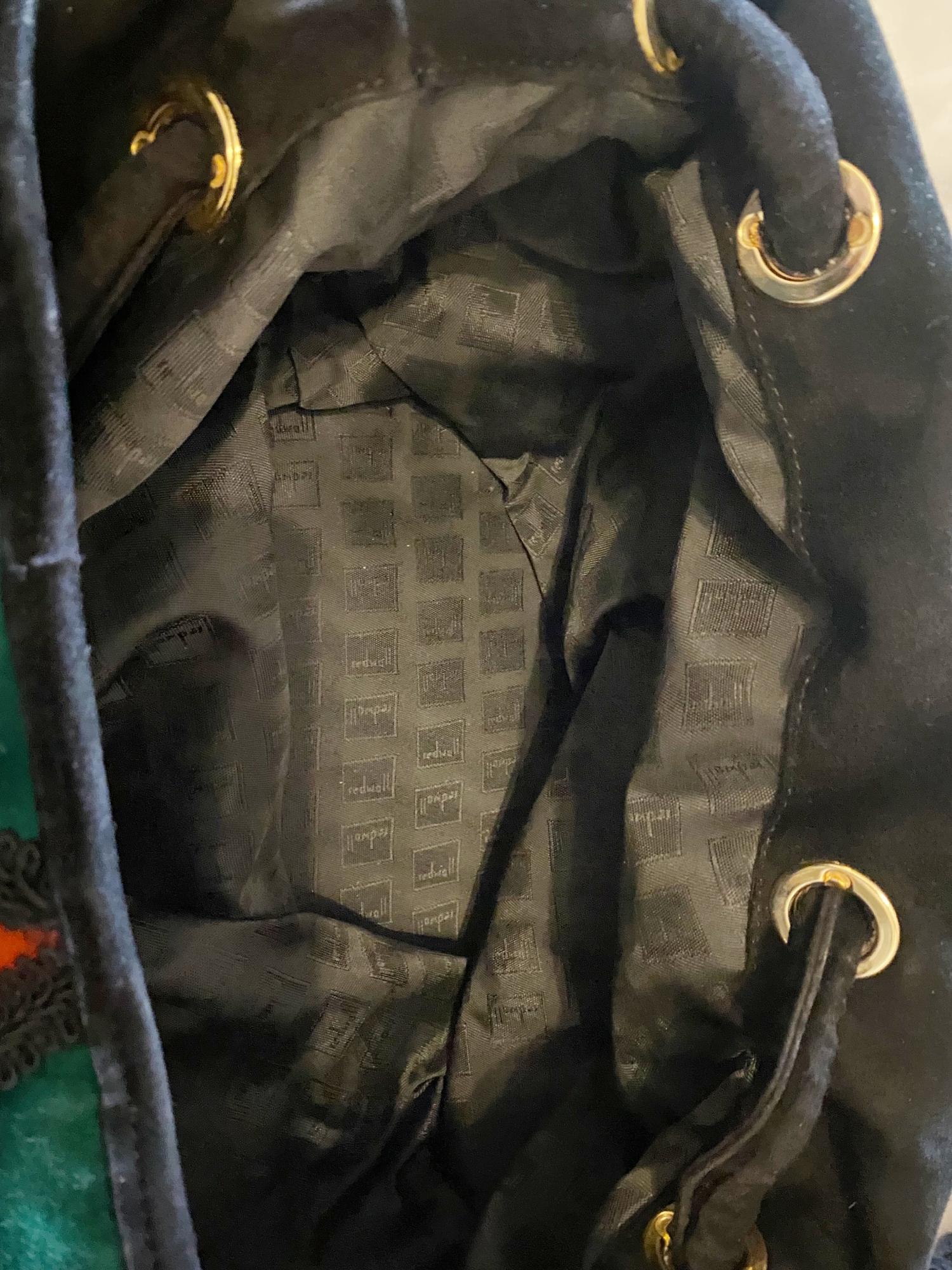 Bolso cubo grande vintage Moschino Colección Arlecchino, estilo marinero, una pieza rara de finales de los años 80-1990. Inspirado en el espíritu juguetón del Arlequín, presenta un diseño de patchwork de ante multicolor en vibrantes tonos joya,