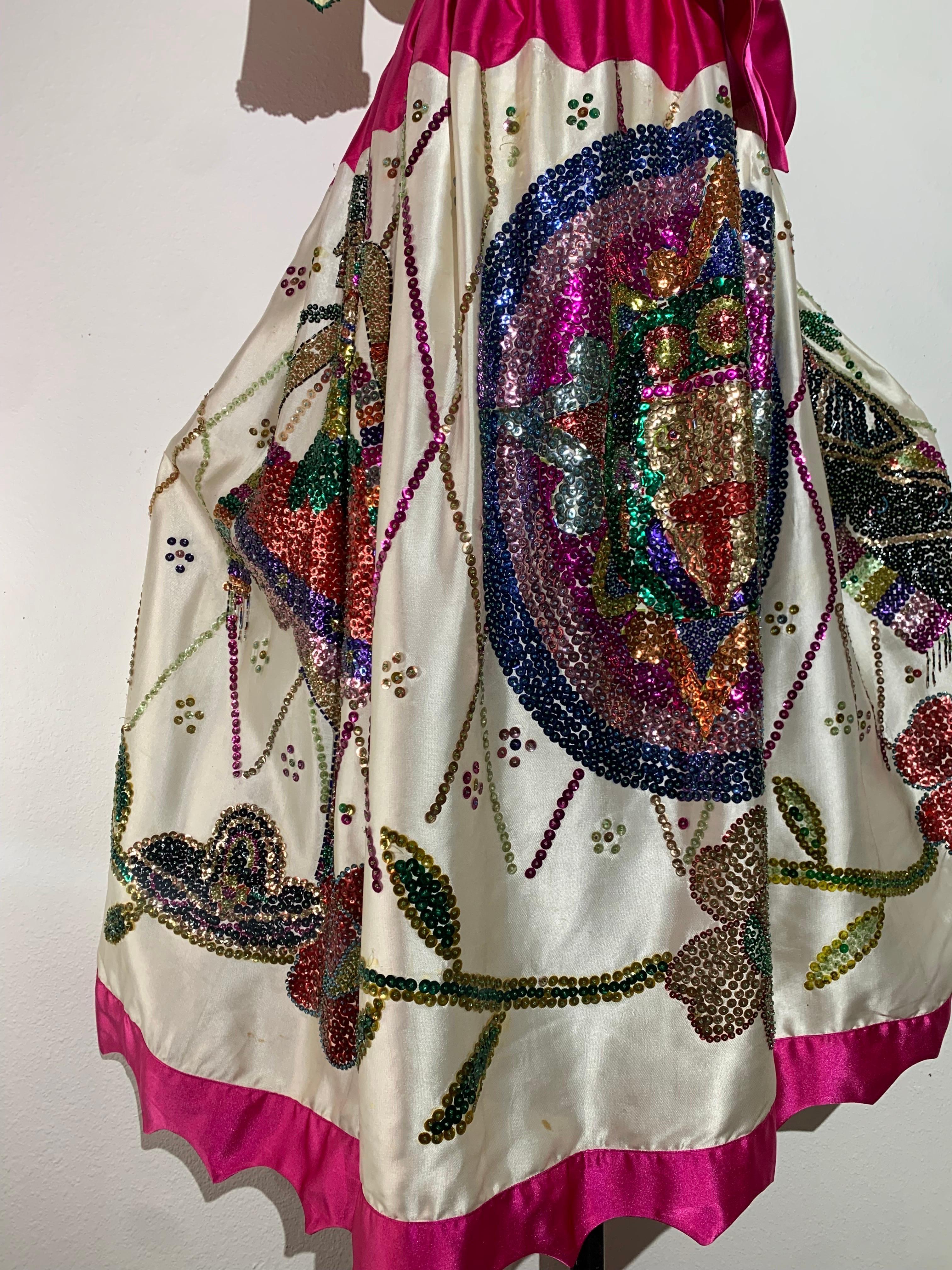 1980s 2-Piece Folkloric White Sateen Beaded & Sequined Mexican-Inspired Festival Set:  Extravagantly beaded in a kaleidoscope of colors in a floral pattern, this skirt and blouse set includes a pink satin wrap-around sash tie and a floral head piece