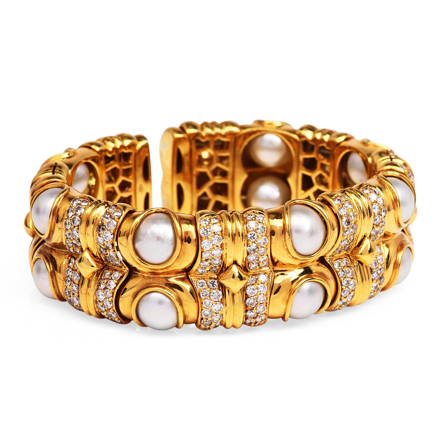 The perfect compliment for a High-quality strand of pearls!

This 1980's bangle cuff bracelet was created in heavy 18K yellow gold, weighing approximately 80.1 grams.

The geometric flexible link design is enhanced by  14 High-luster 8 mm grayish
